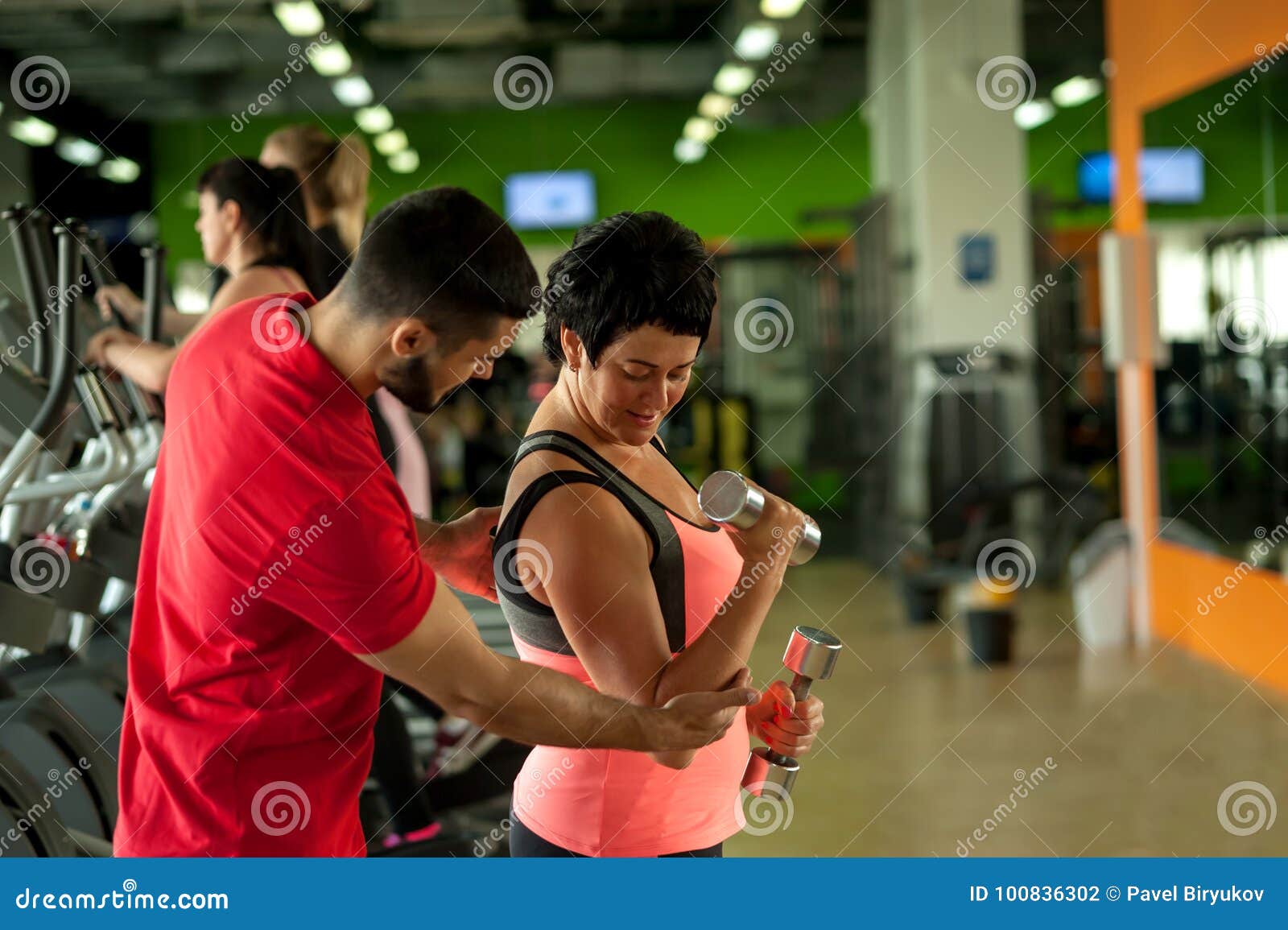 Fitness Coach Assisting His Female Client In Gym Stock Photo Image Of