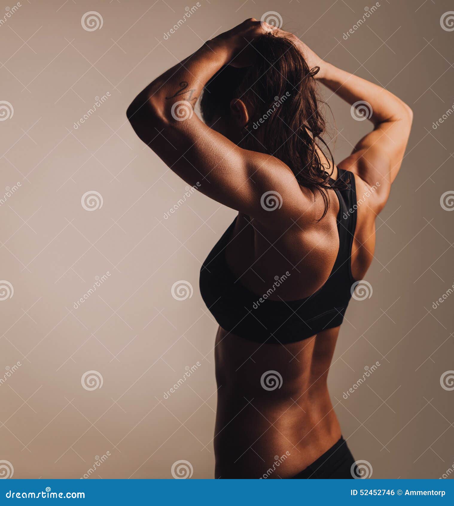 Woman flexing her muscles and showing her toned back Royalty-Free
