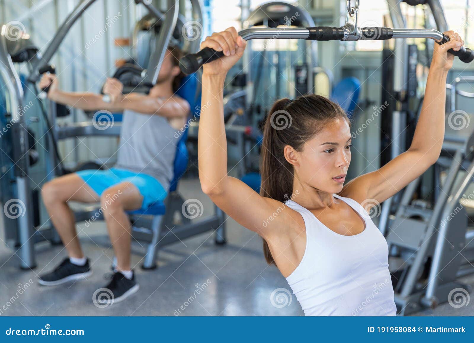 Fitness Girl Working Out Shoulders and Upper Back at Lat Pulldown