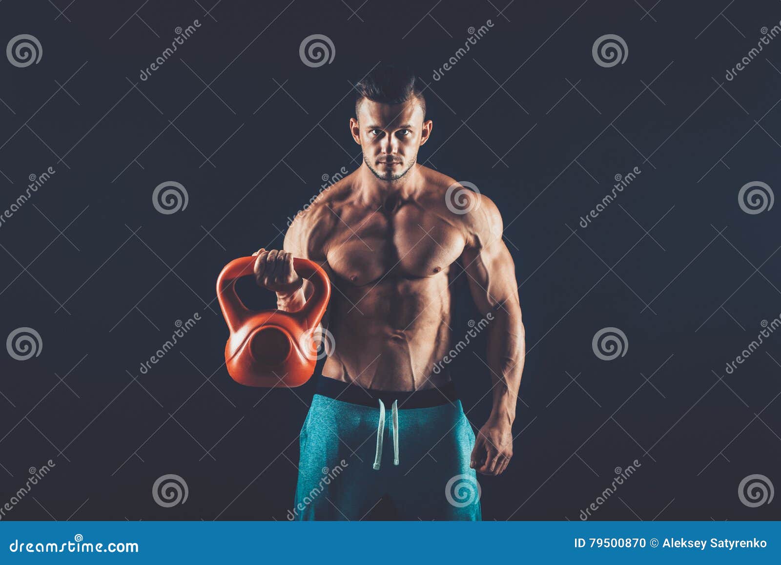 Fitness Man Doing a Weight Training by Lifting Heavy Kettlebell Stock