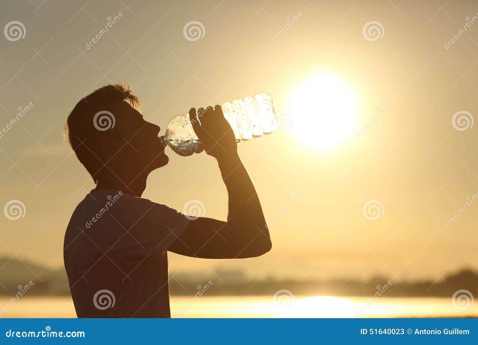 fitness man silhouette drinking water from a bottle