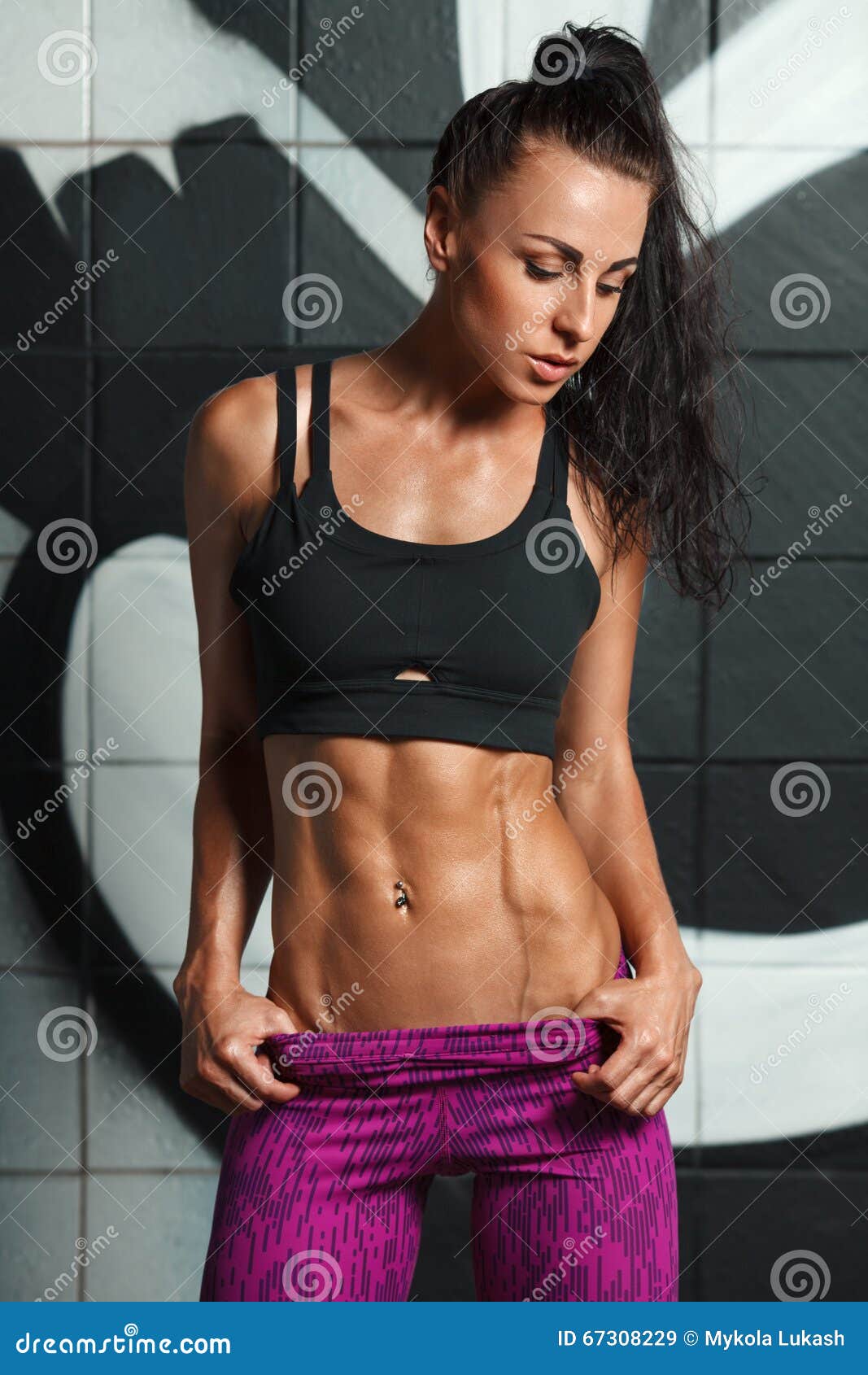 Fitness Woman Showing Abs and Flat Belly. Beautiful Muscular Girl