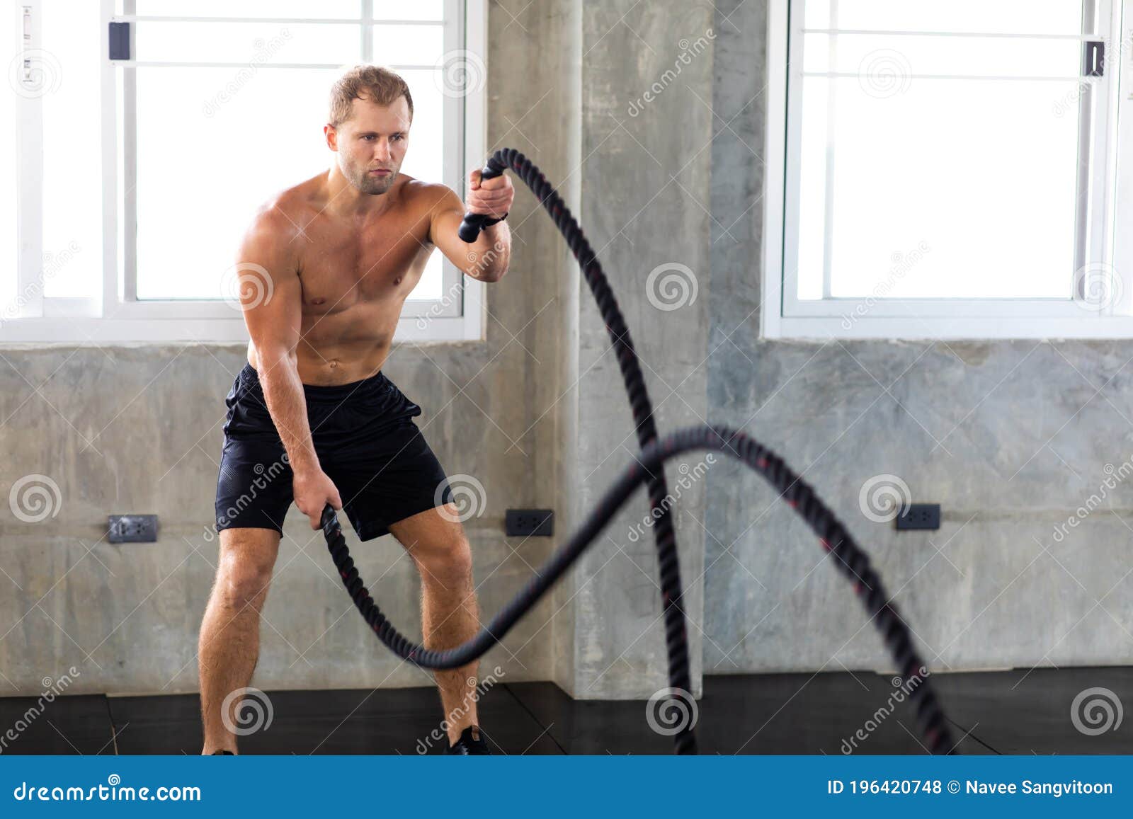 fitness and sports man training with battle rope in cross fit gym. fitness healthy lifestye and workout at gym concept