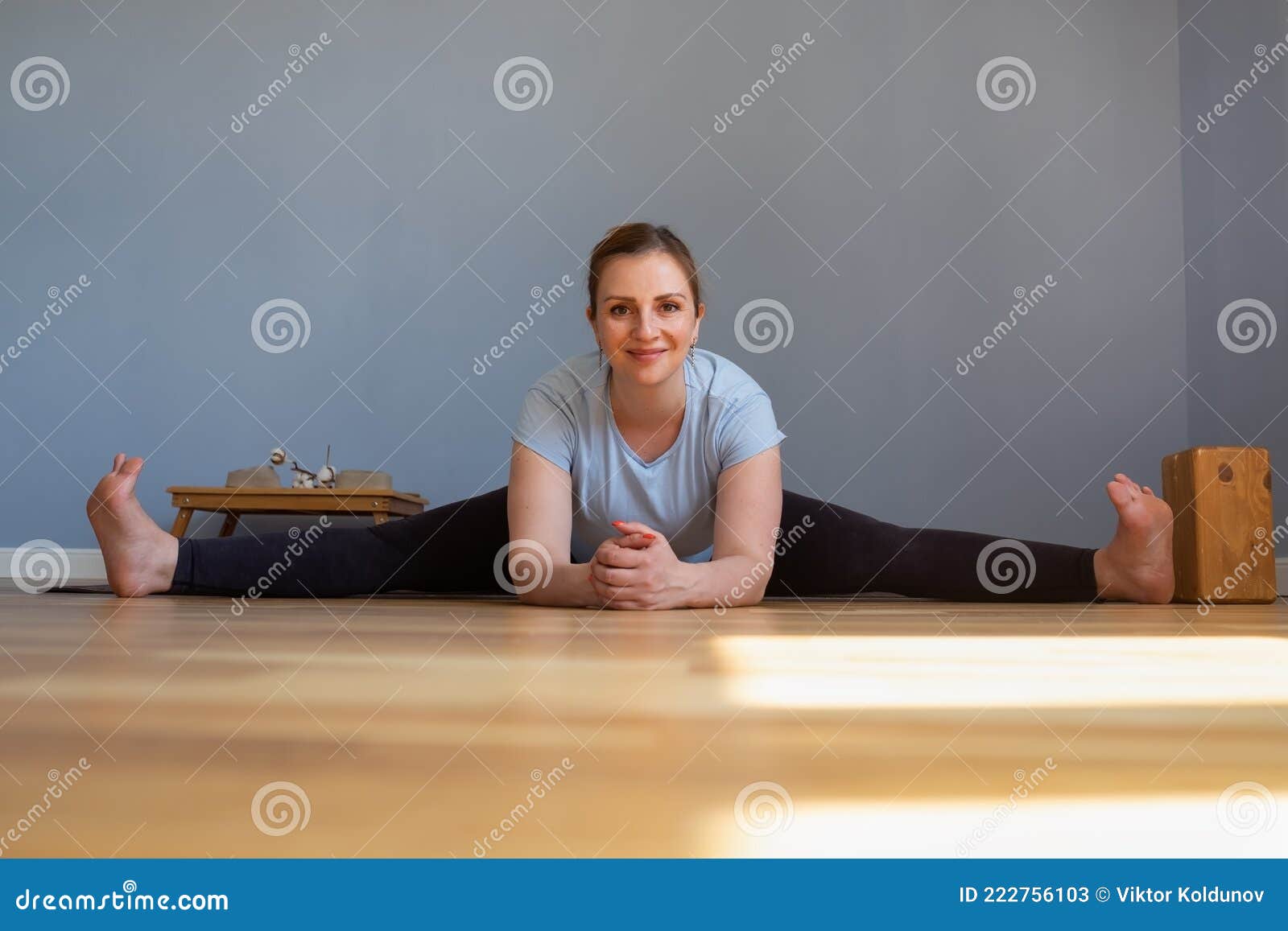 pregnant woman working out doing seated straddle posture, upavishtha konasana
