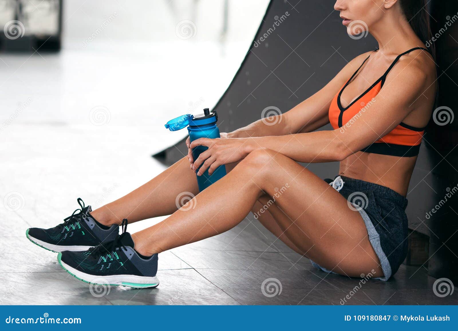 fitness woman with a bottle of water. active girl quenches thirst, workout
