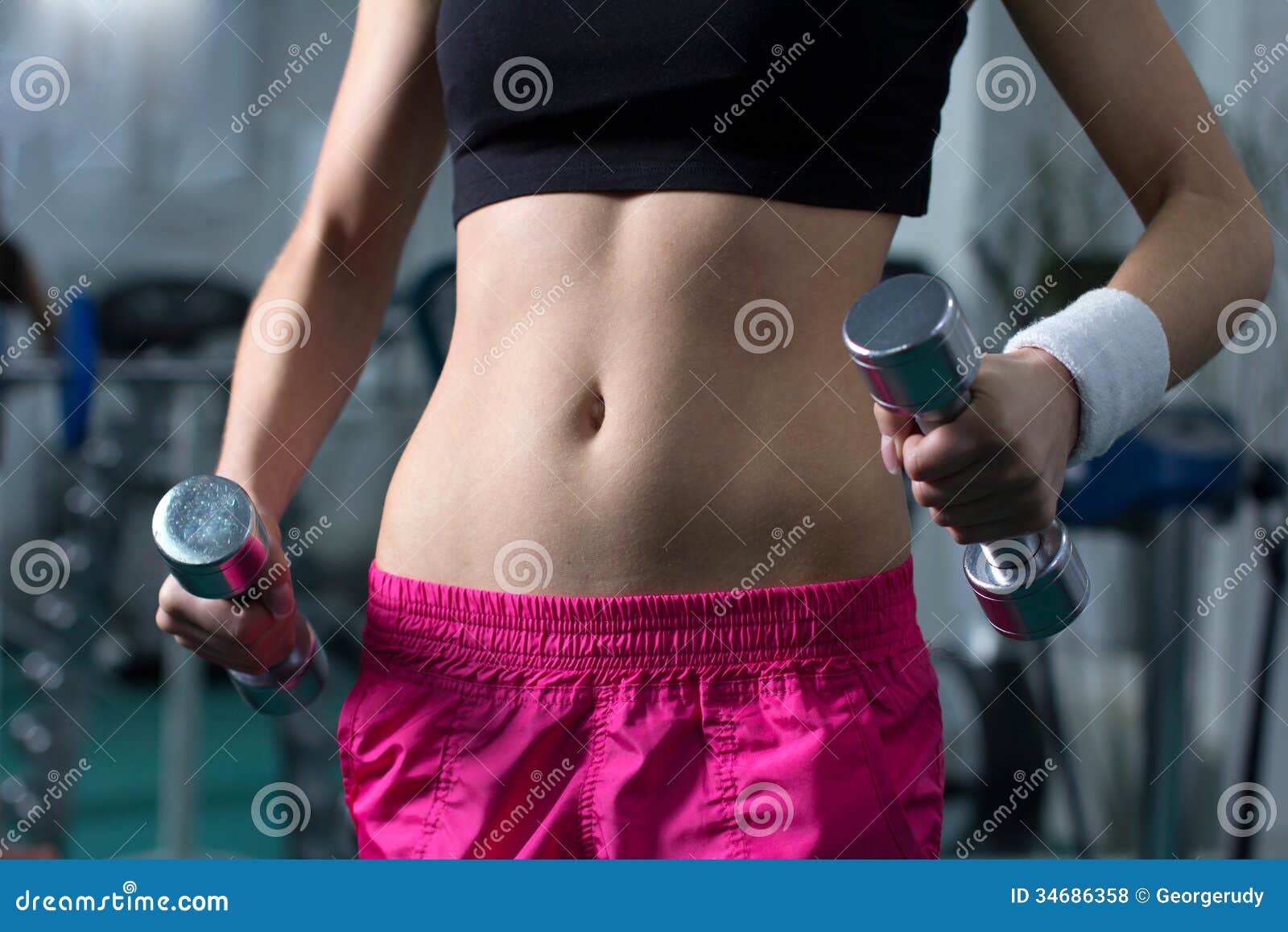 Fitness Woman. Close-up of torso of female holding barbells