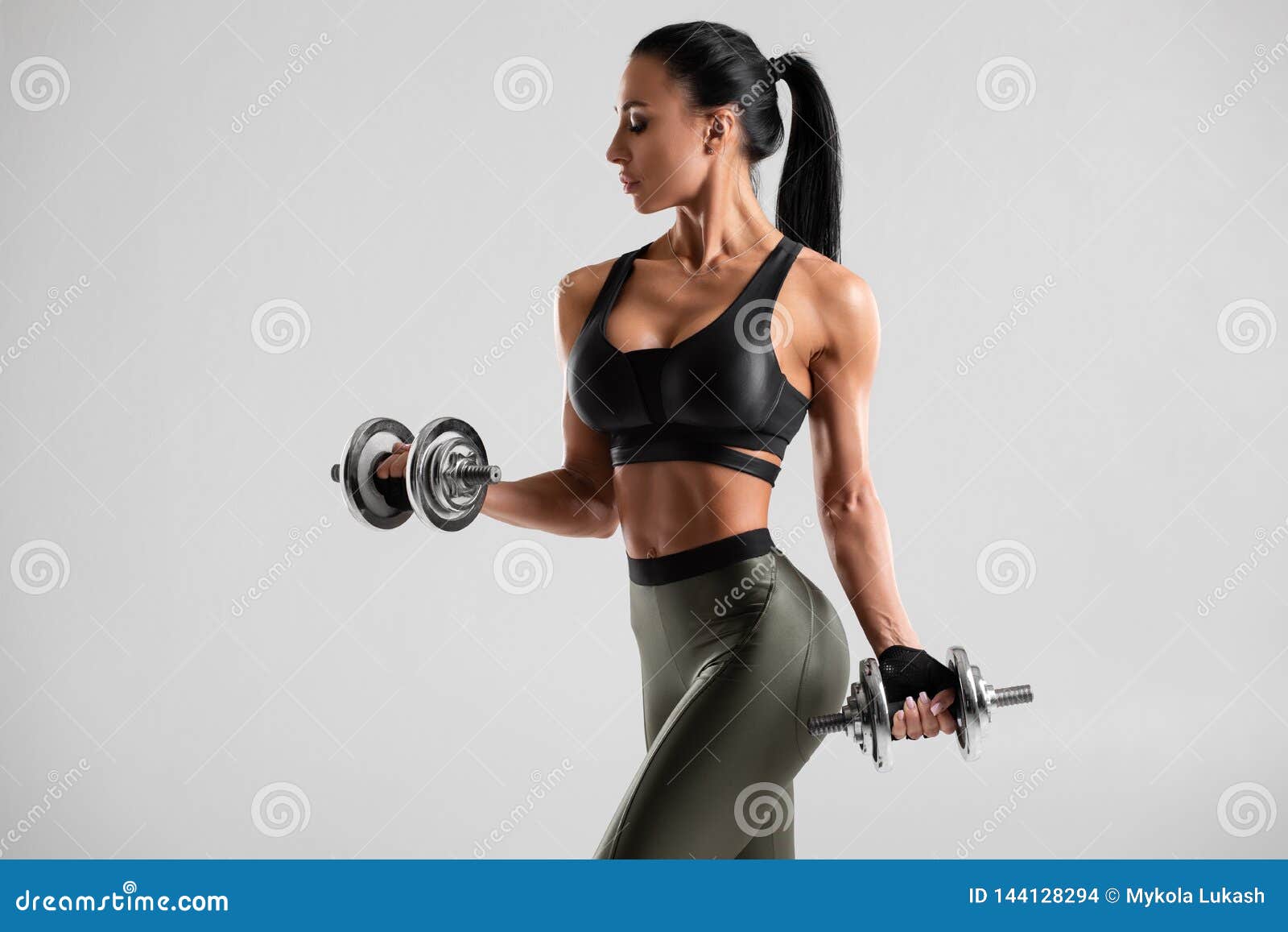 Fitness Woman Doing Exercise for Biceps on Gray Background