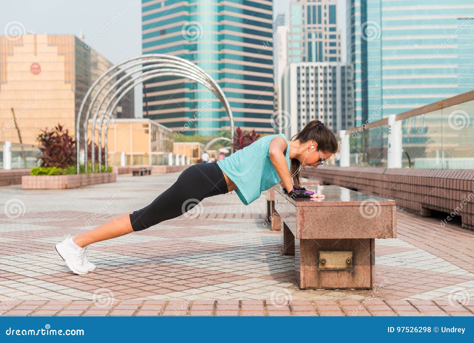 Fitness Woman Doing Feet Elevated Push Ups On A Bench In The City