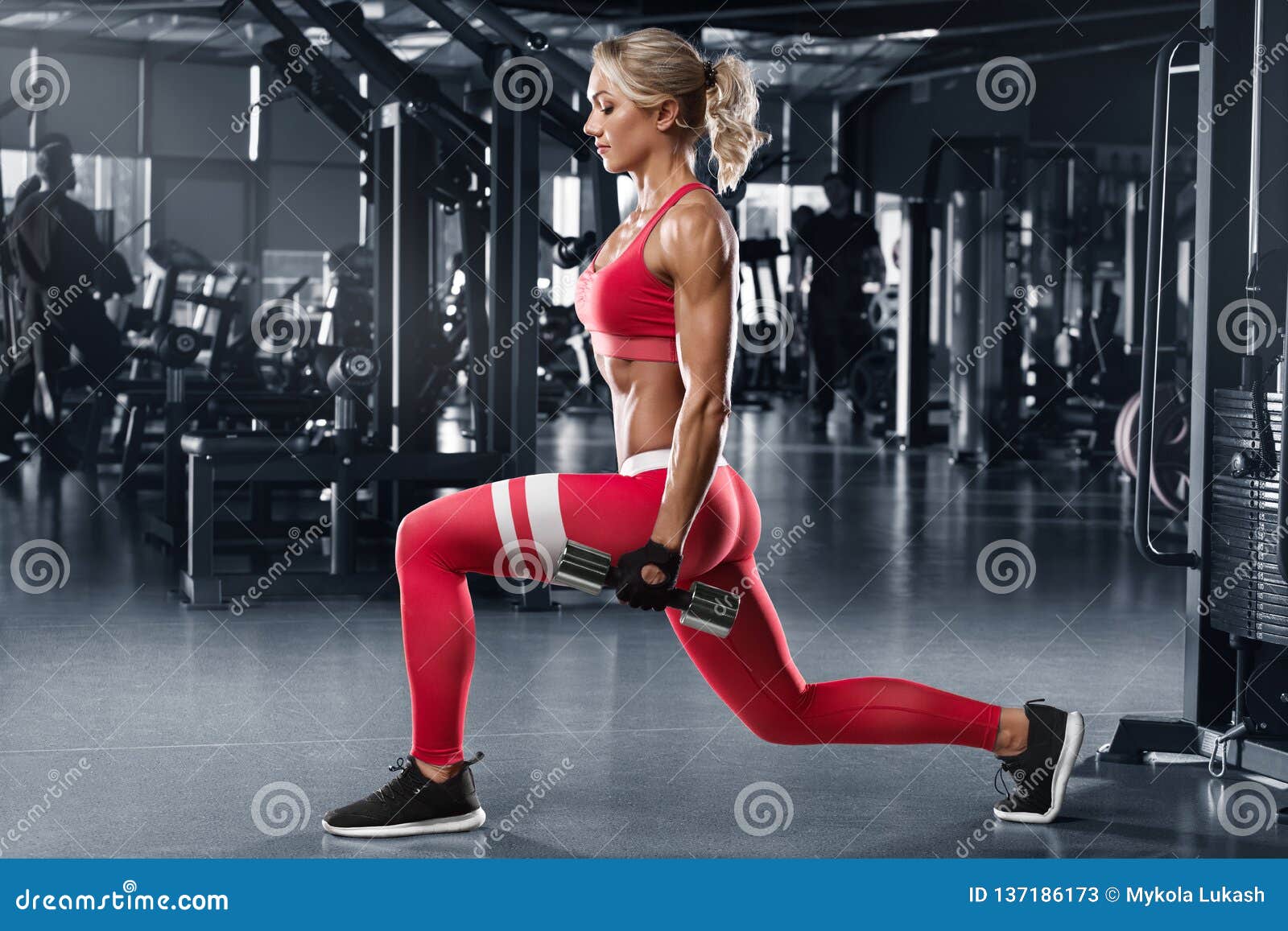 fitness woman doing lunges exercises for leg muscle workout in gym. active girl doing front forward one leg step lunge