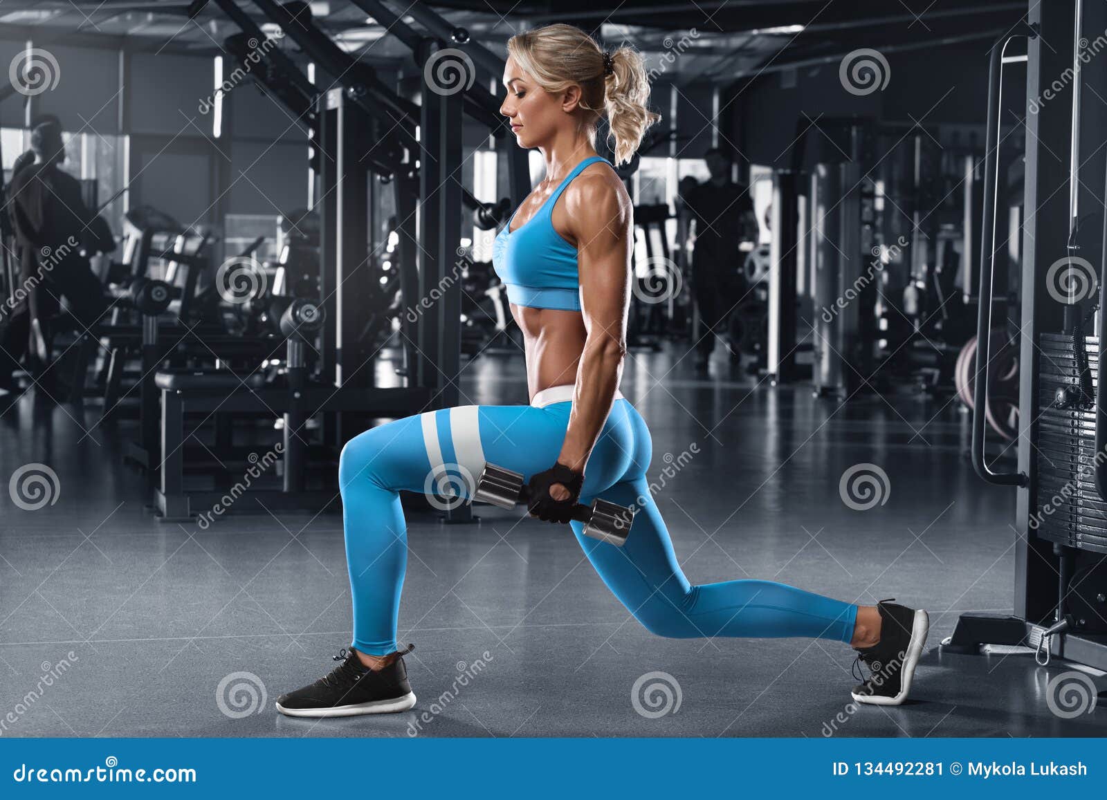 fitness woman doing lunges exercises for leg muscle workout training in gym. active girl doing front forward one leg step