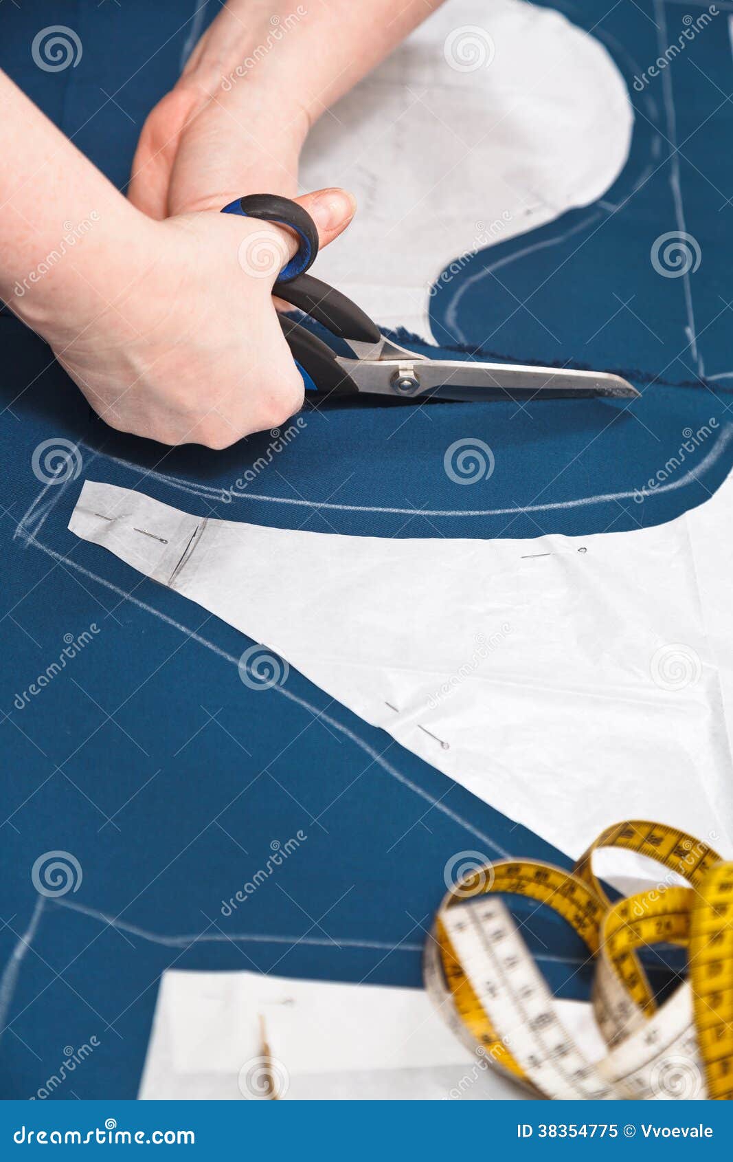 fitter cuts out dress according with pattern