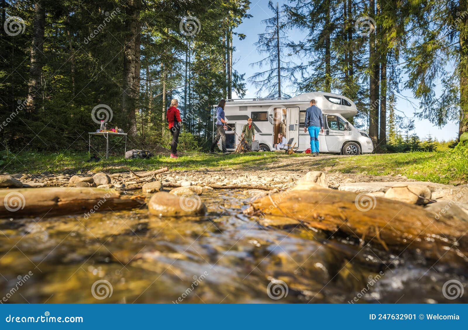 five-caucasian-people-their-motorhome-road-trip-camping-riverside-rv-dry-campsite-friends-hanging-next-to-campfire-247632901.jpg