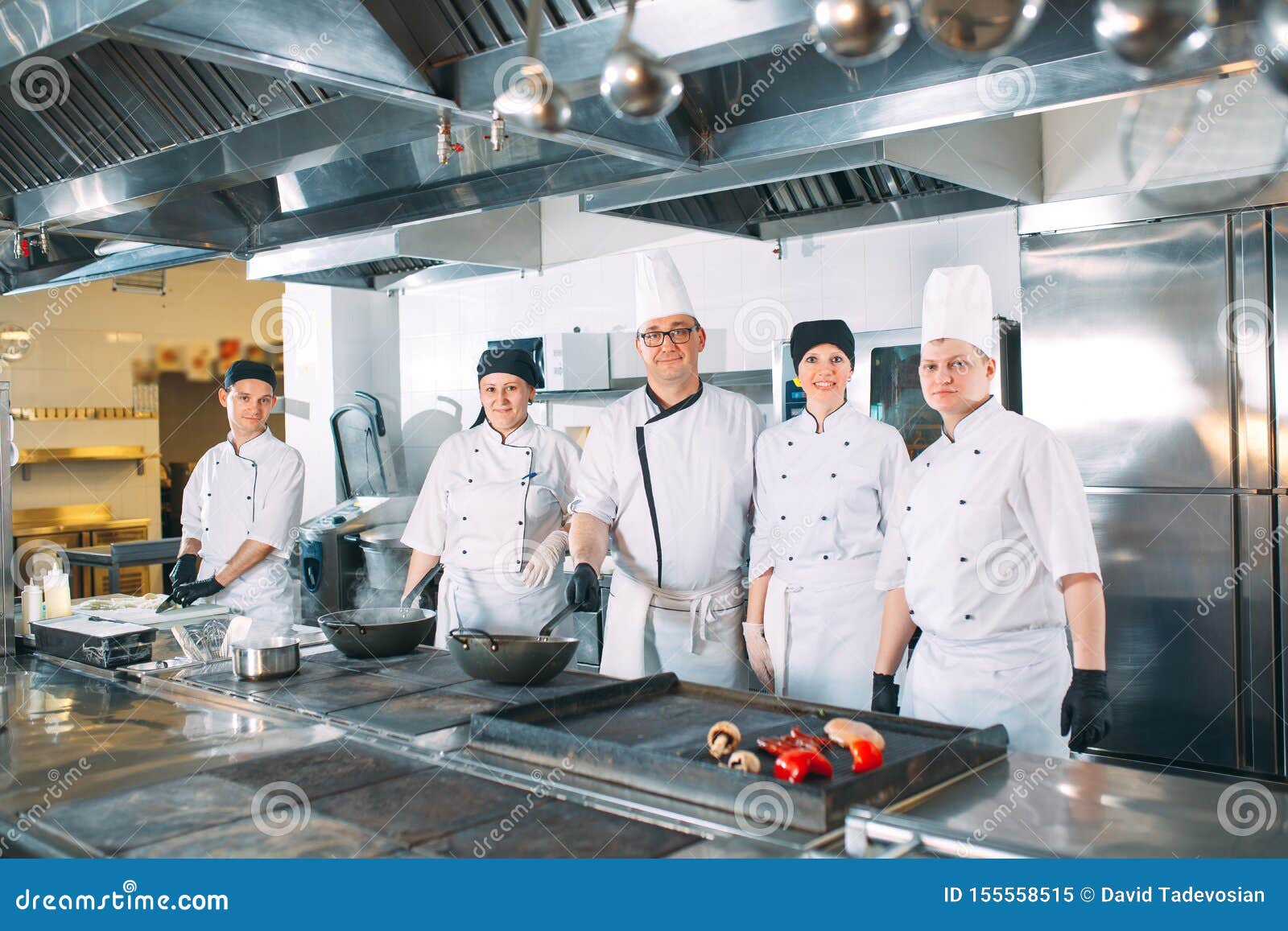 Five Chefs Wearing Uniforms Posing in a Kitchen. Stock Image Image of