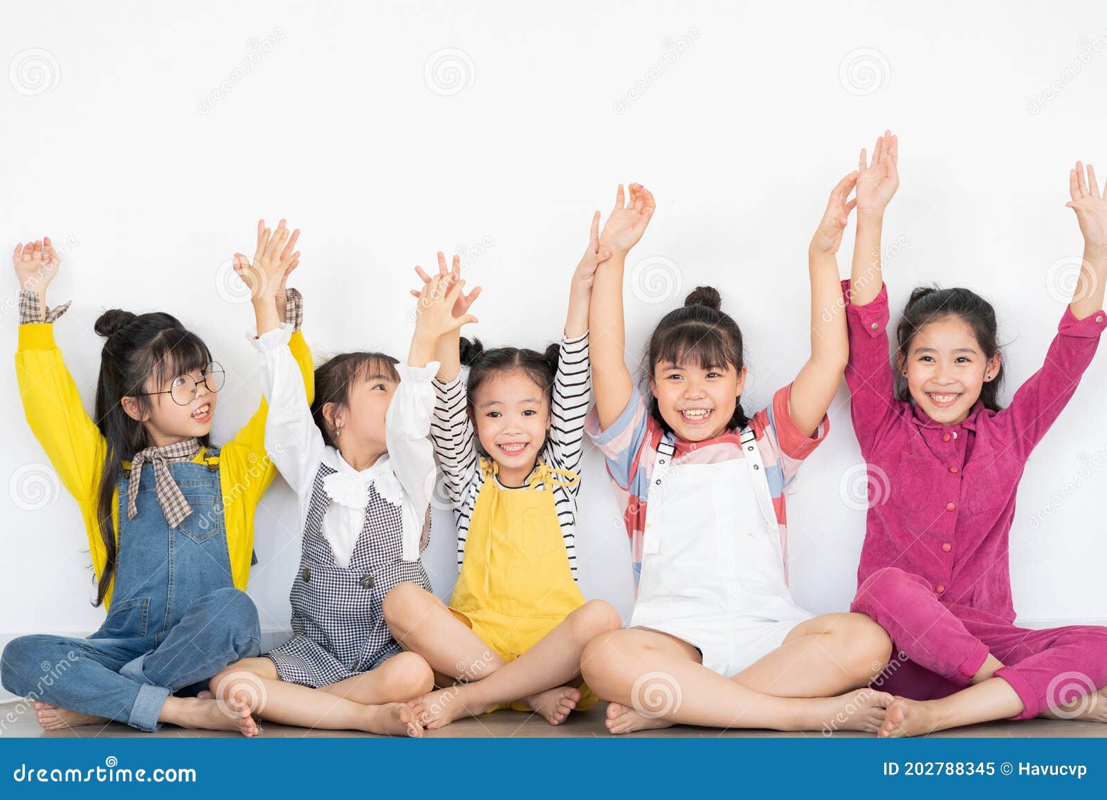 five little girls raising their hands