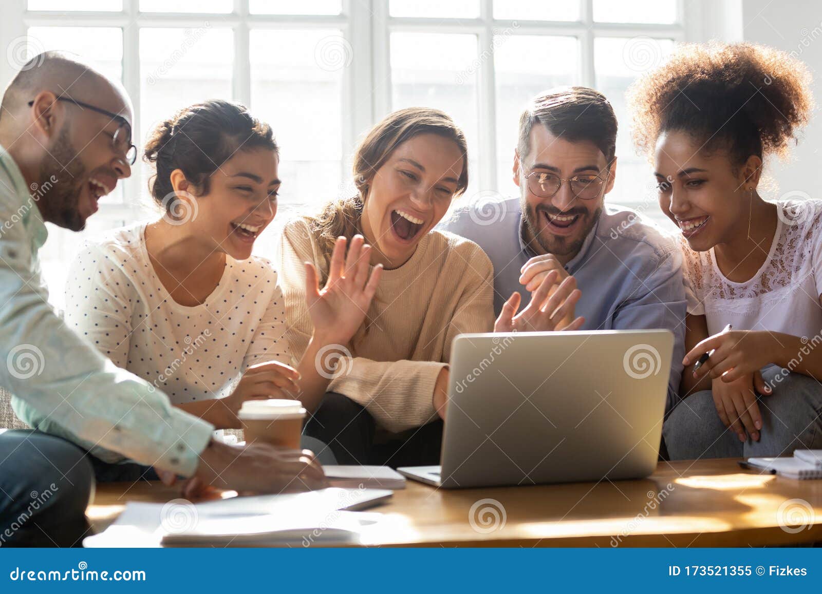 five multi-ethnic friends make videocall looking at laptop screen