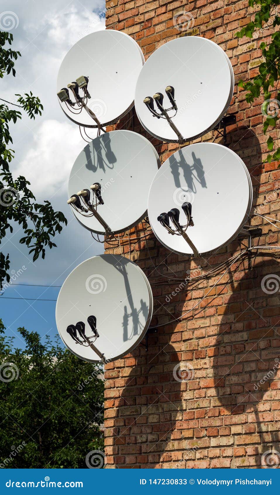 Five Satellite Dish Antennas are Mounted on the Wall of a Brick