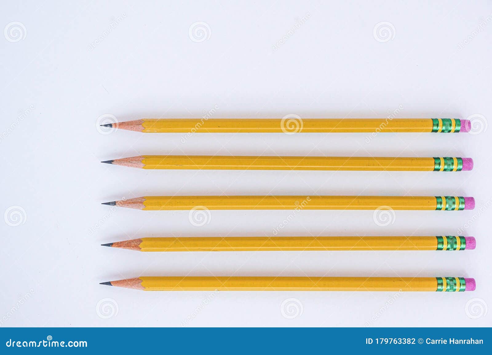 five sharpened pencils lay on a white background