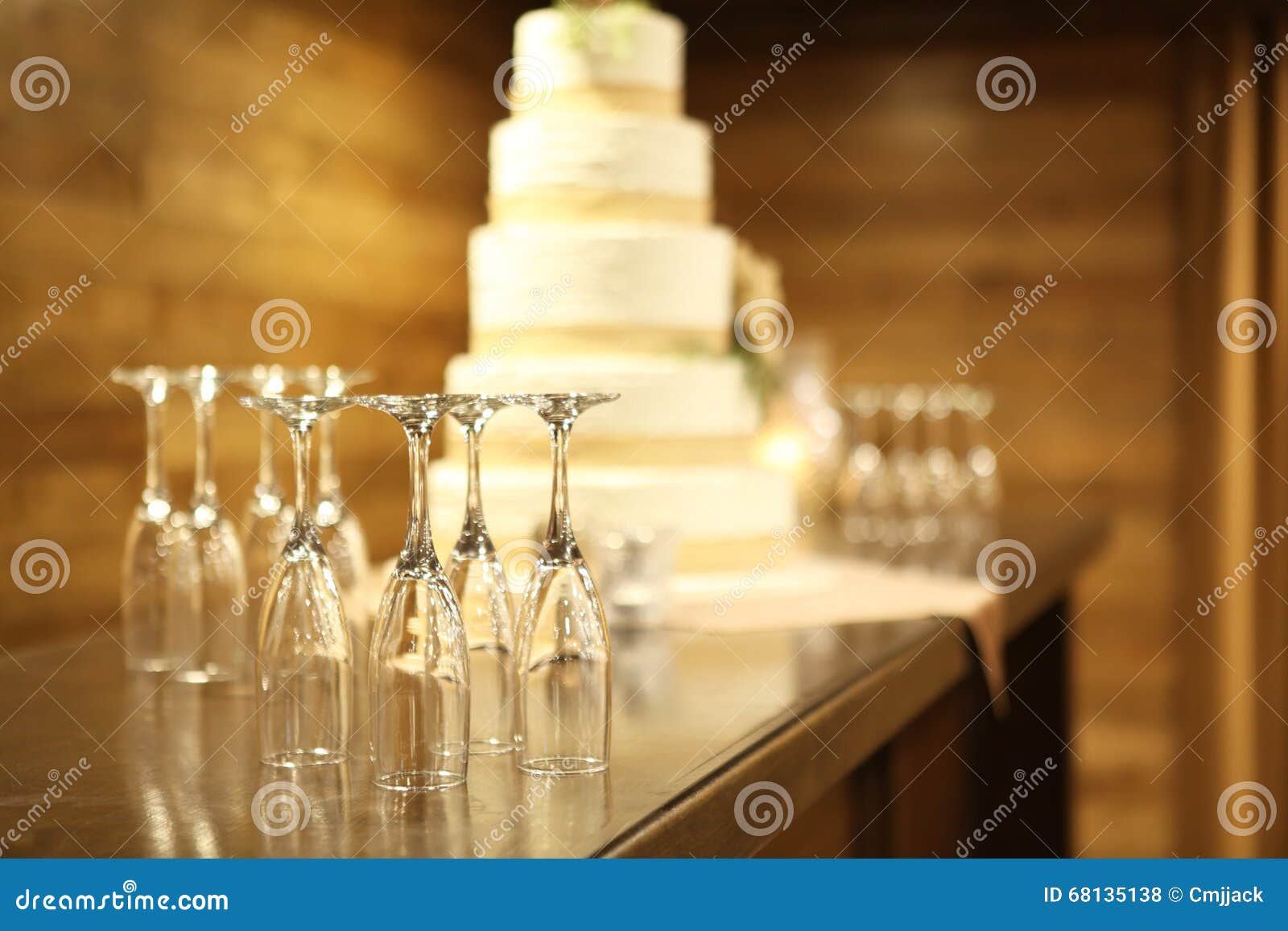 Five Tiered Wedding Cake with Empty Champagne Flutes on Table Stock