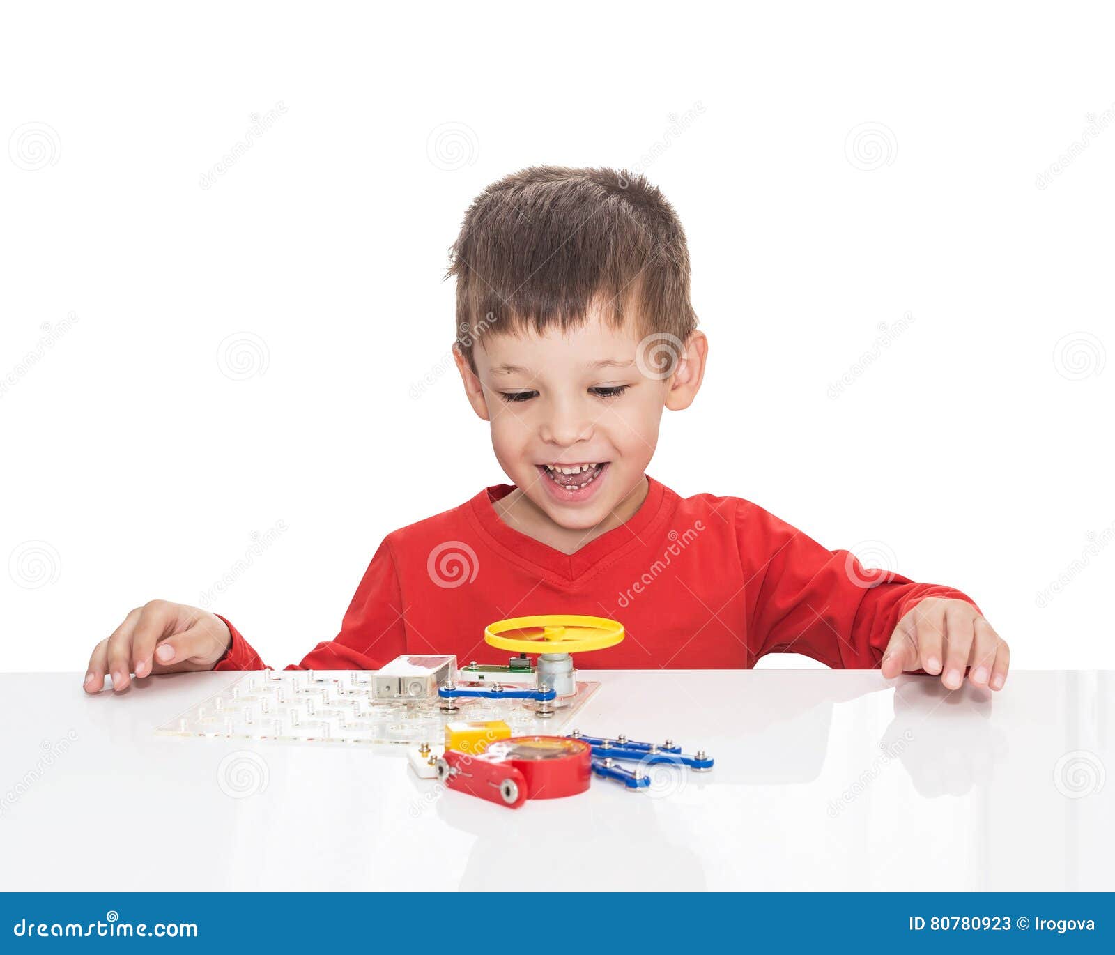 The Fiveyearold Boy Sits at a White Table and Plays an Electronic Designer Stock Image Image
