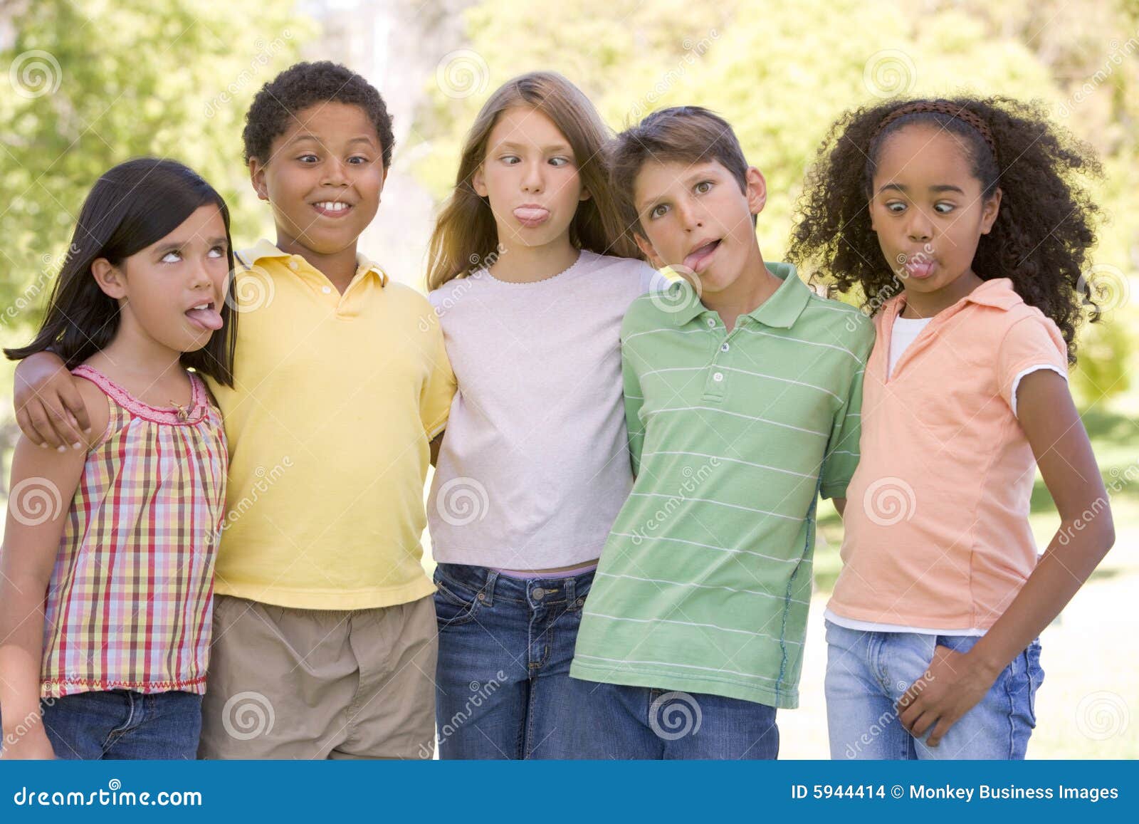 five young friends outdoors making funny faces