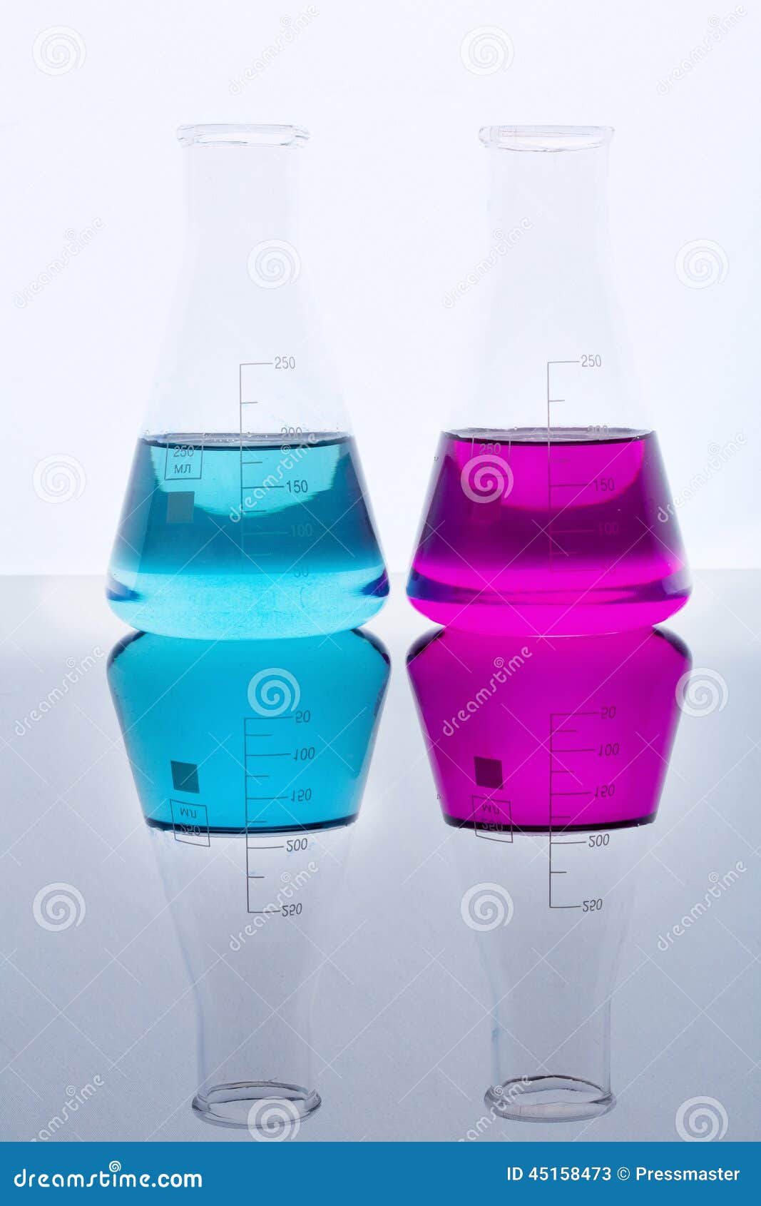 На столе стоят три склянки с водой. Колба с фиолетовой жидкостью. Колба с бирюзовой жидкостью. 2 Колбы с синей жидкостью. Мерная колба с красно фиолетовой жидкостью.