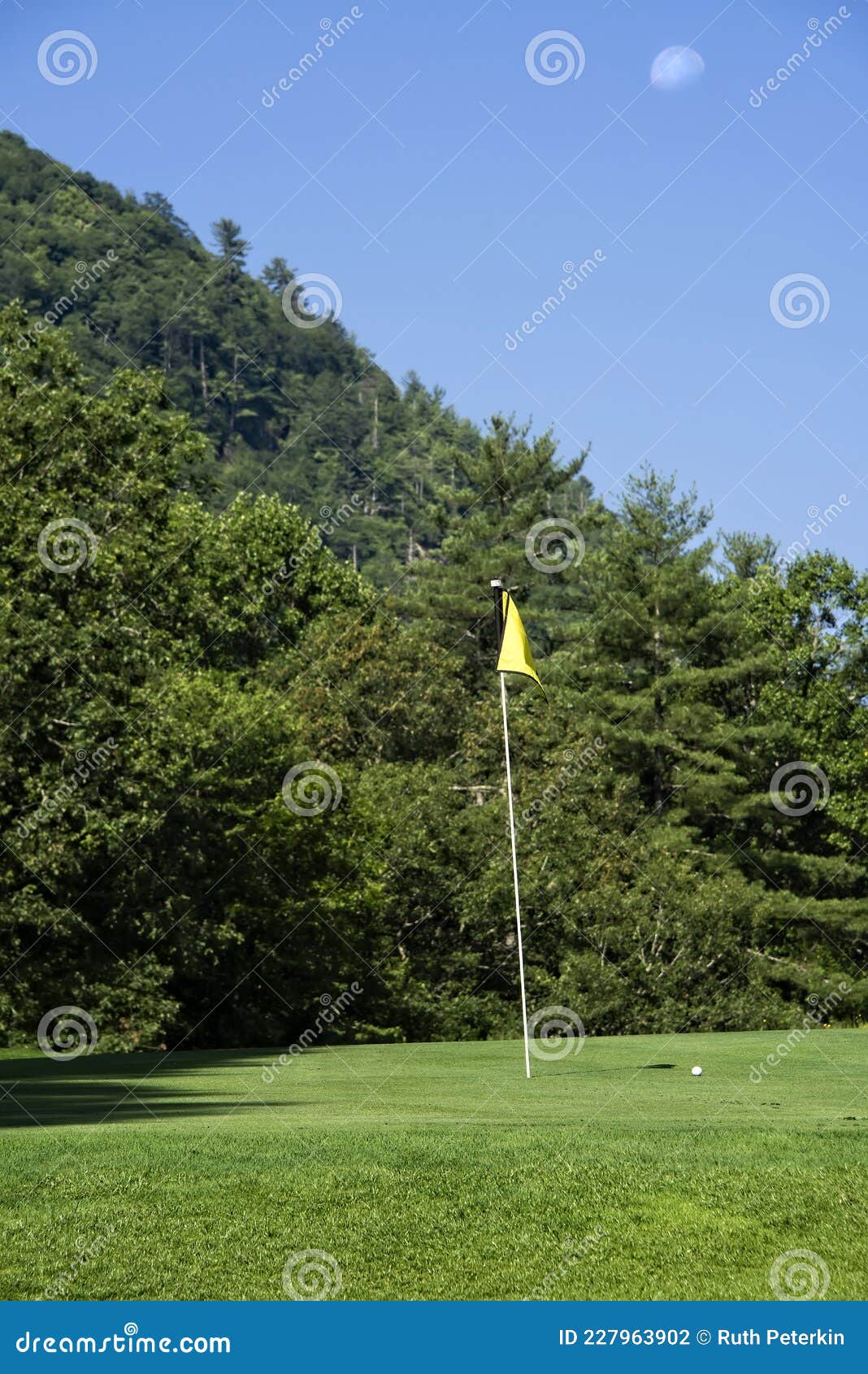 Flag and Golf Ball, with the Moon Overhead Stock Photo Image of