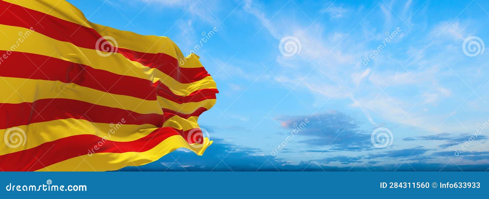 flag of ibero-romance peoples catalans at cloudy sky background, panoramic view. flag representing ethnic group or culture,