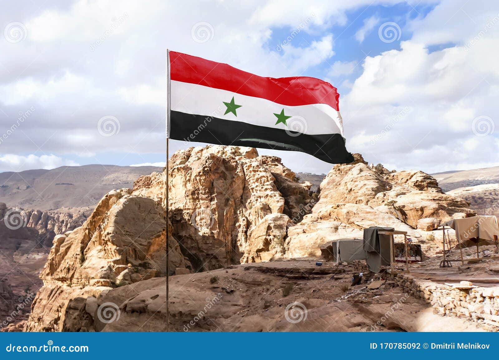 Flag of Syria on a Flagpole Flutters in the Wind Against the Sky