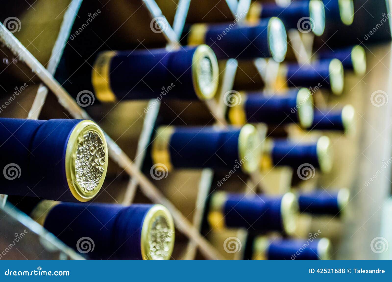 Viele Flaschen Wein mit Blau- und Goldkapseln in einem Weinkeller