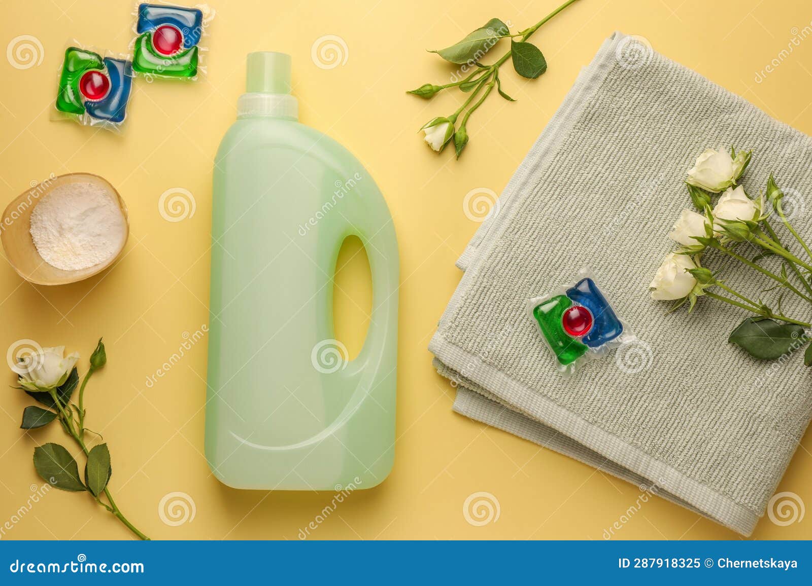 Flat Lay Composition with Bottles of Fabric Softener on Pale Yellow