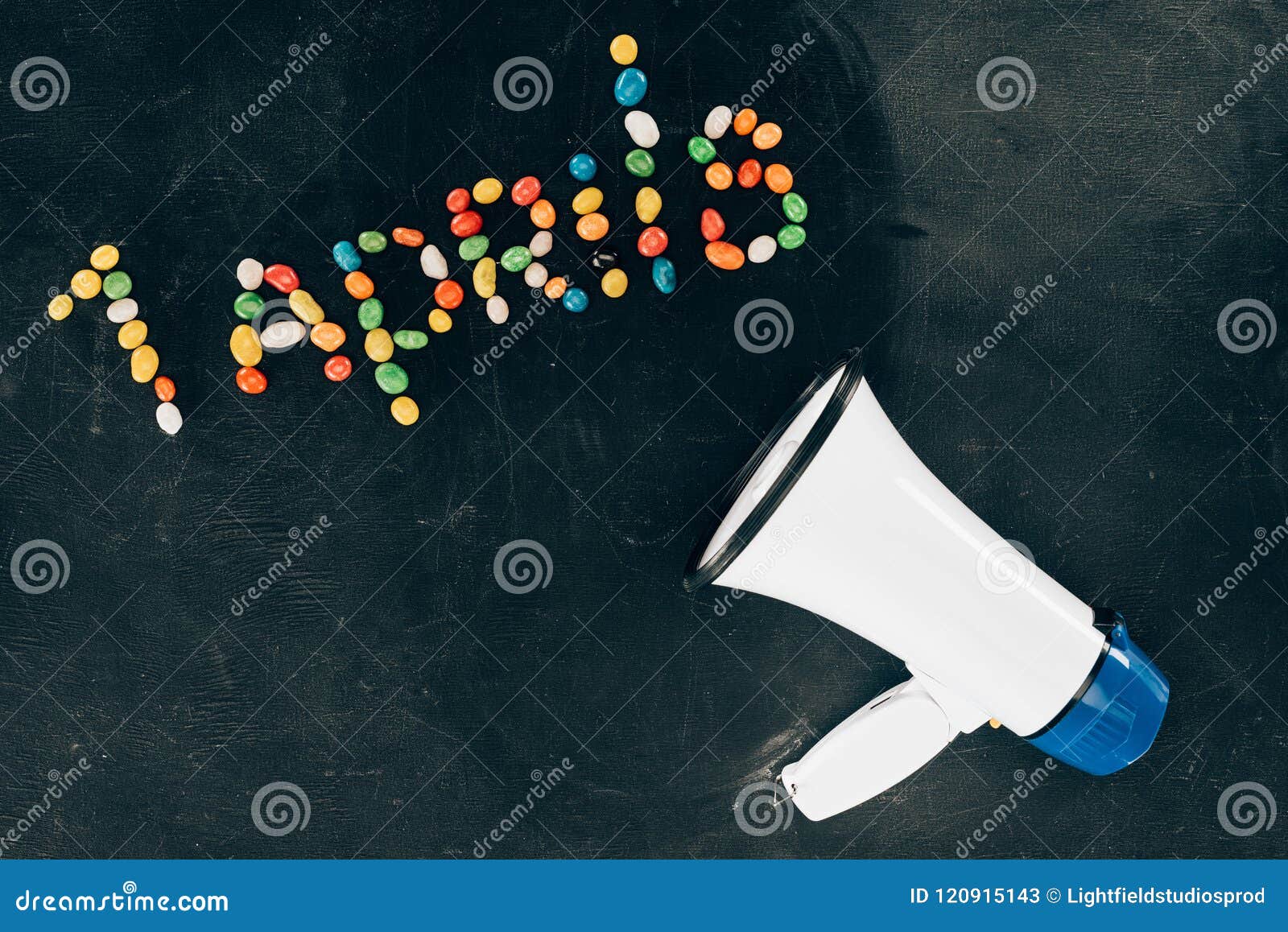flat lay with loudspeaker and candies arranged in 1 aprils lettering