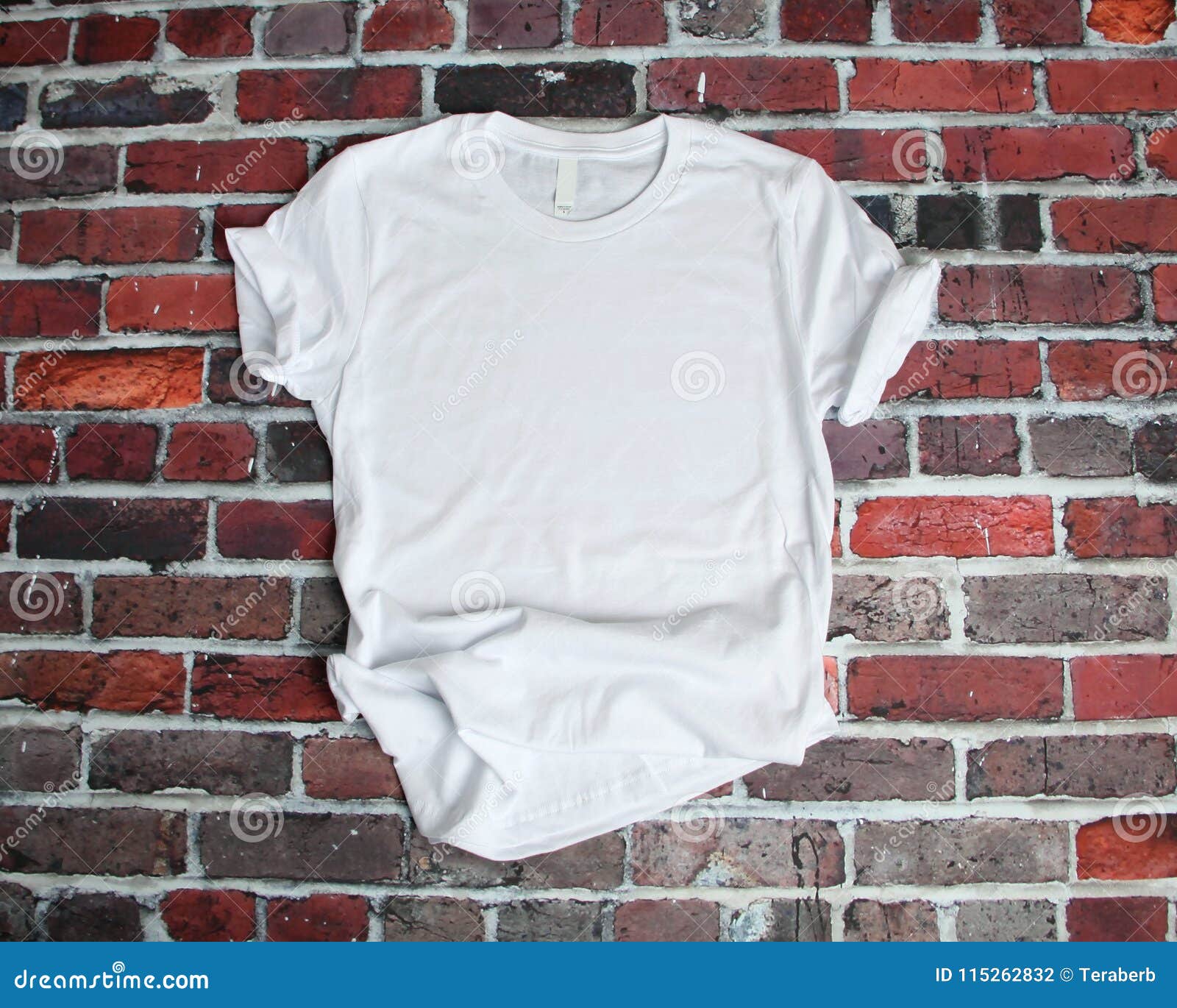 flat lay mockup of white tee shirt on brick background