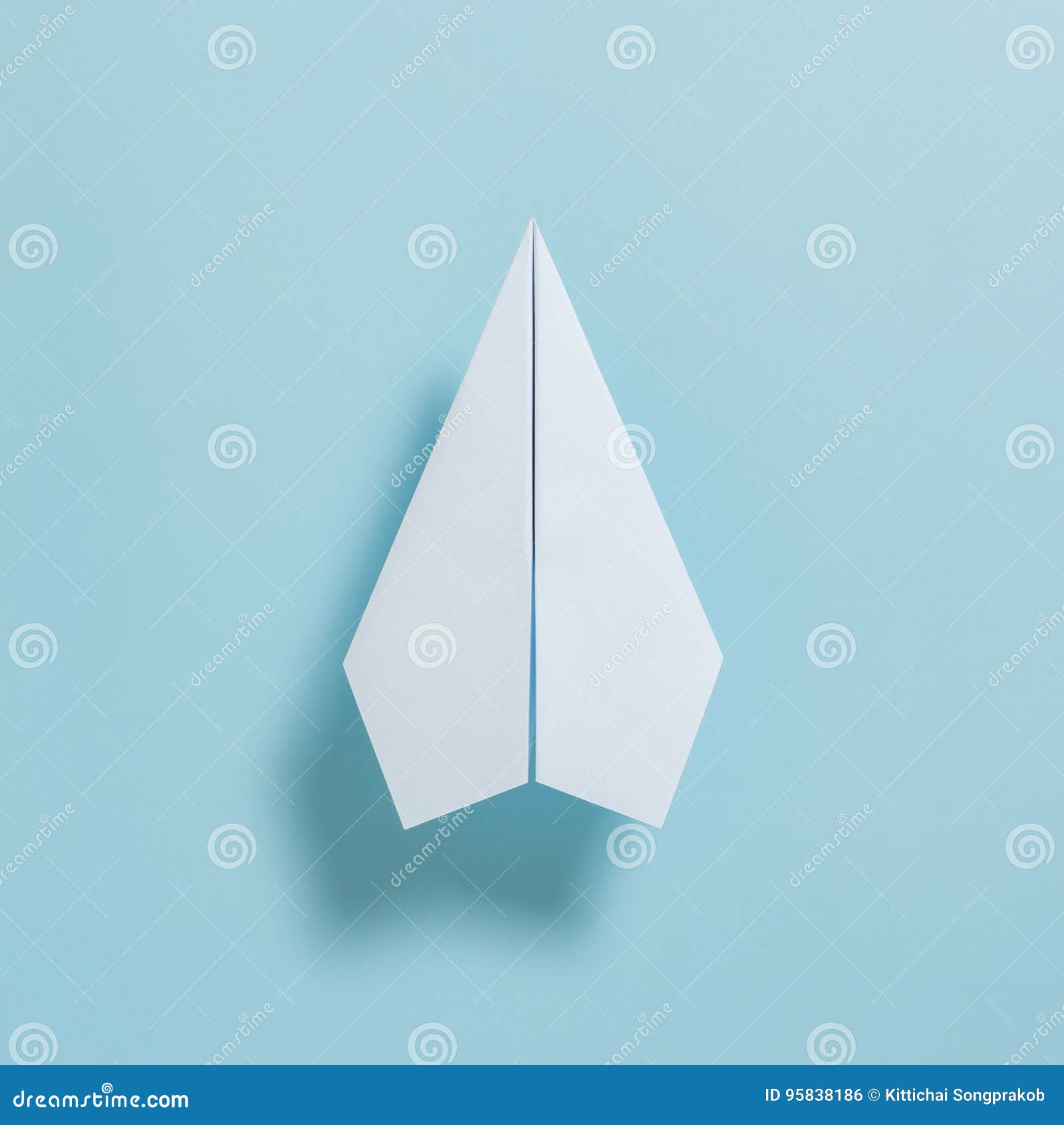 Flat Lay of White Paper Plane on Pastel Blue Color Background Stock