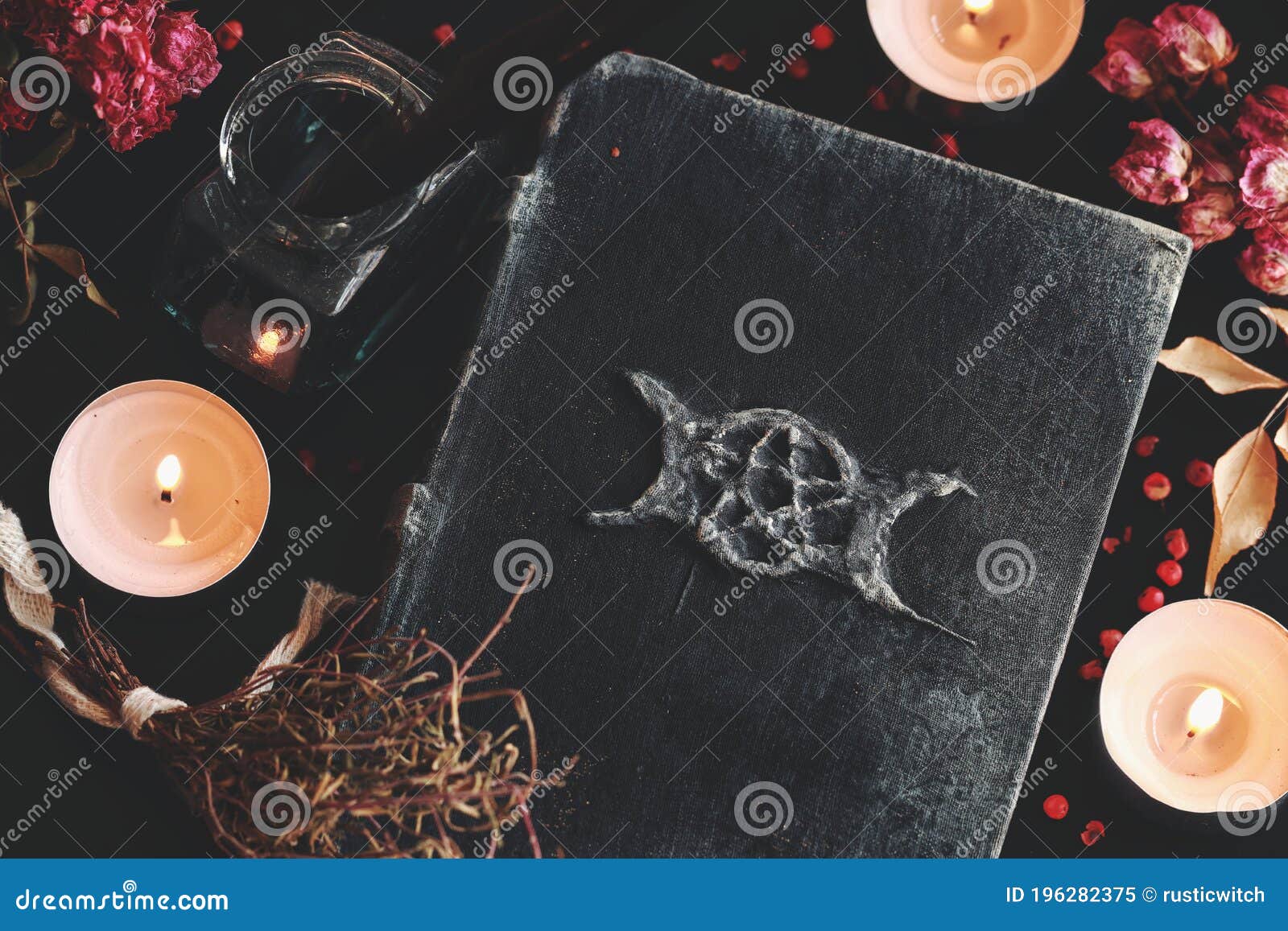 flat lay of witch`s altar with a hand made grimoire with triple moon 