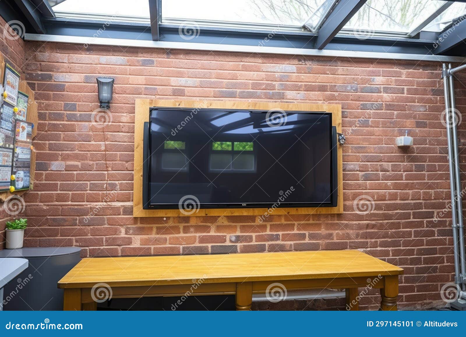 A Flat Screen Tv Mounted on a Brick Wall in a Room Stock Image