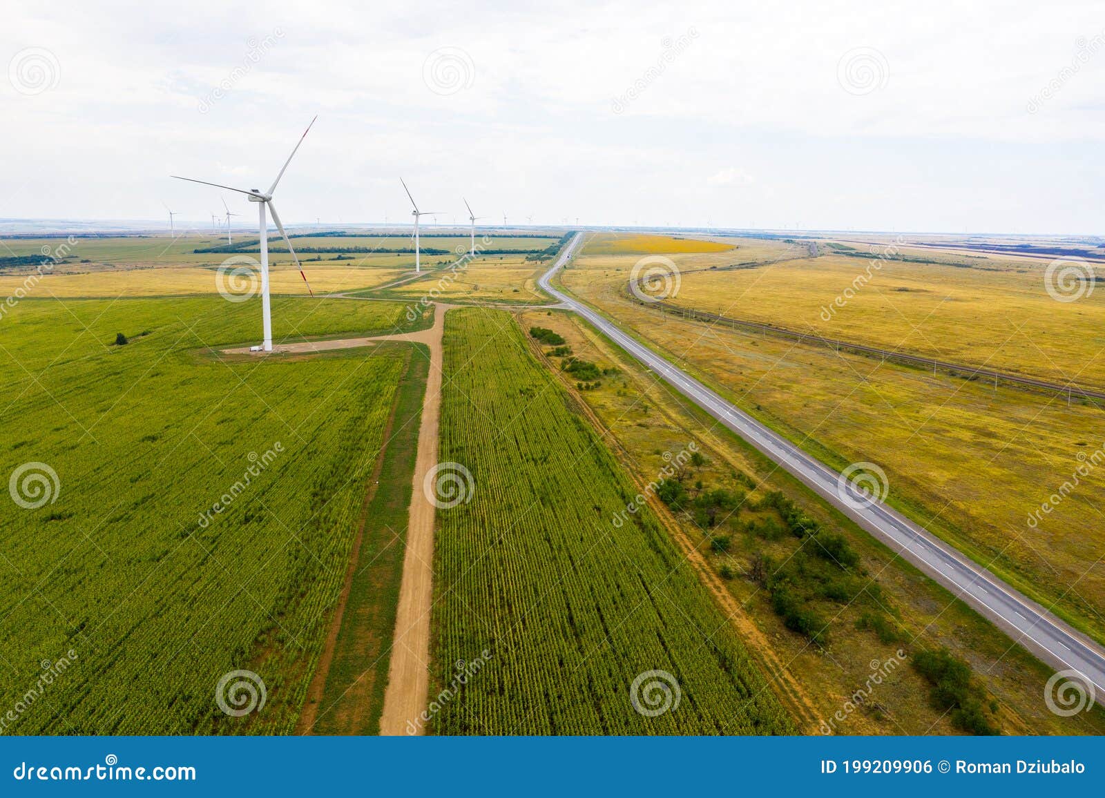 flat terrain with lots of wind turbines in the fields and a highway stretching into the distance. the view from the top.