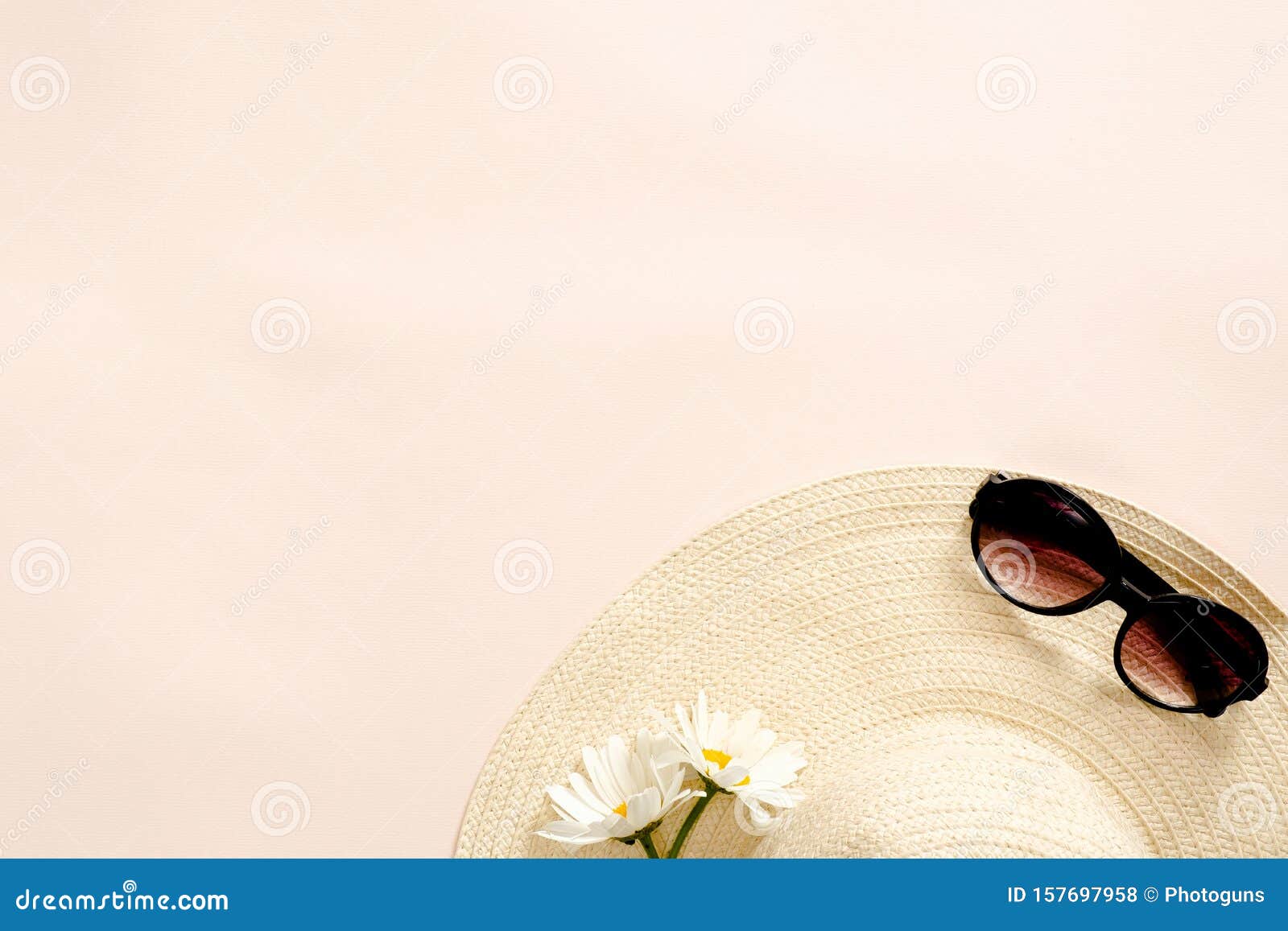 flatlay composition with straw hat, daisy flowers and sunglasses on pastel pink background. flat lay, top view, copy space. summer