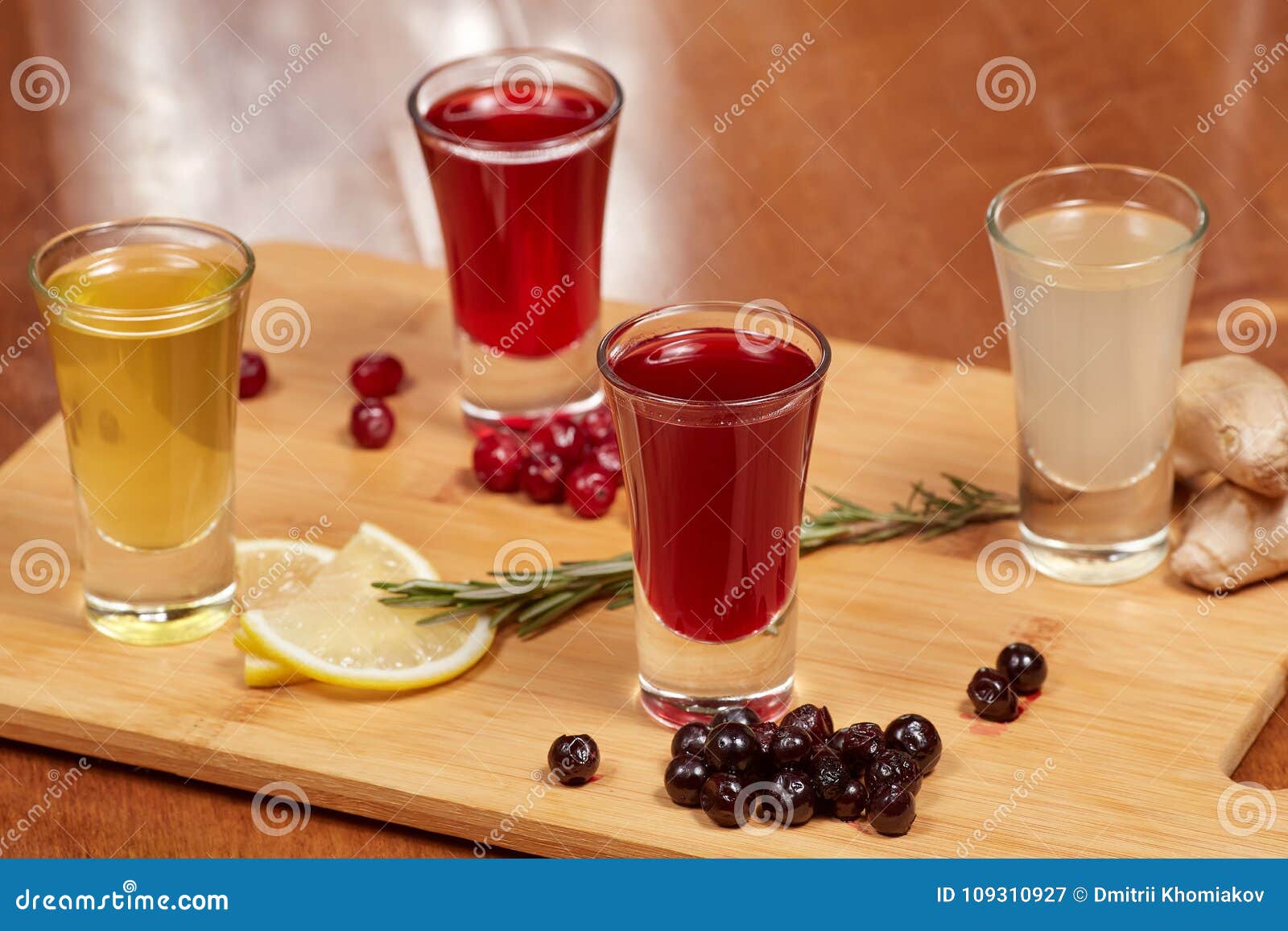 Flavored Fruit Liqueurs on Wooden Board. Citrus, Berries, Ginger Stock
