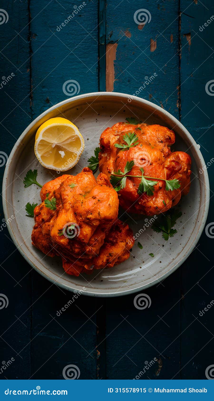 flavorful chicken malai boti served with lemon on a dish