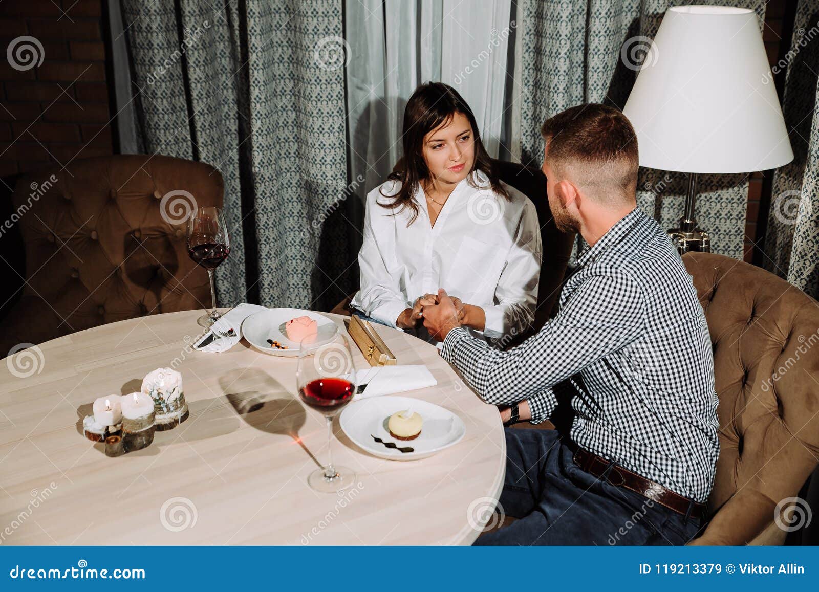 Flertar em um café Pares loving bonitos que sentam-se em um café que aprecia no vinho e na conversação Amor e romance