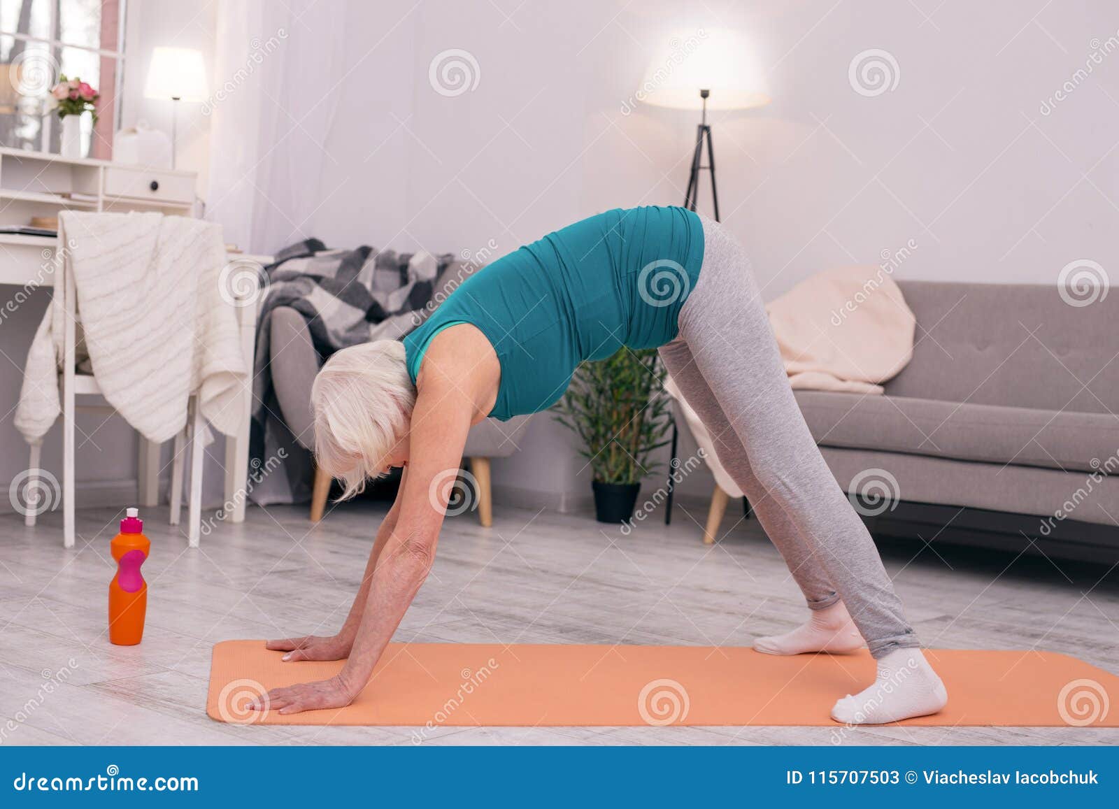 athletic young woman standing in downward-facing dog asana
