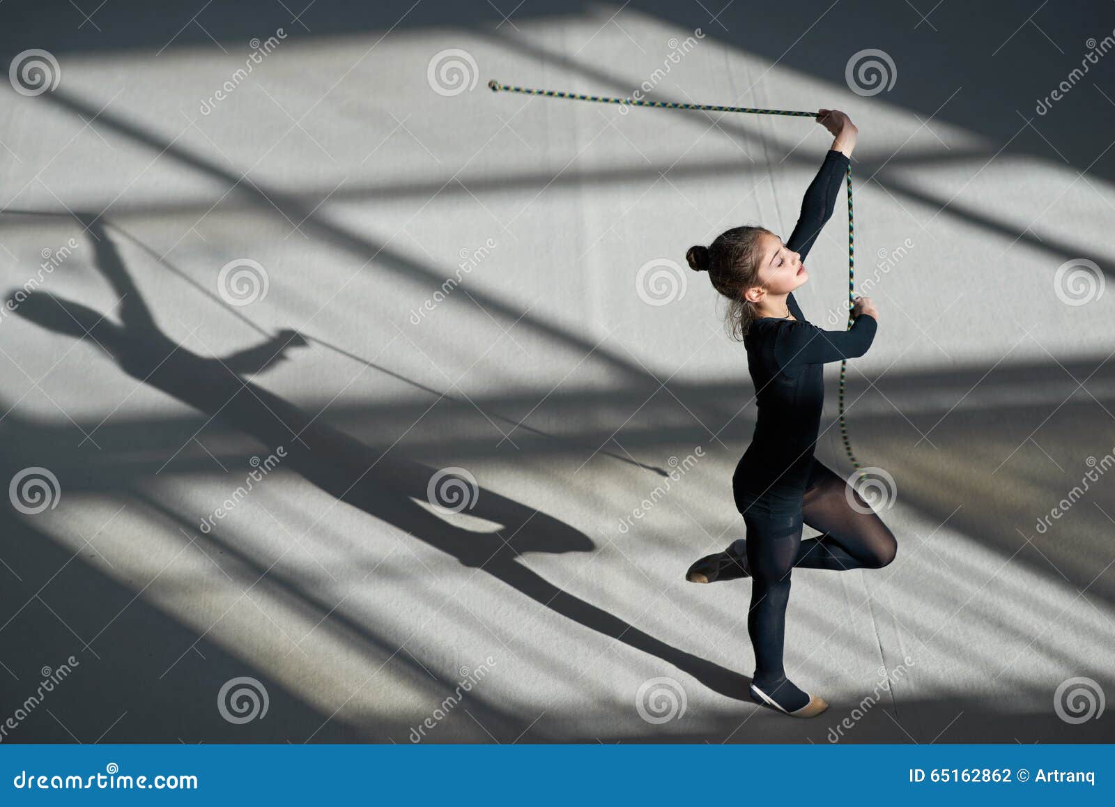 Flicka som övar med repet på den rytmiska gymnastiken