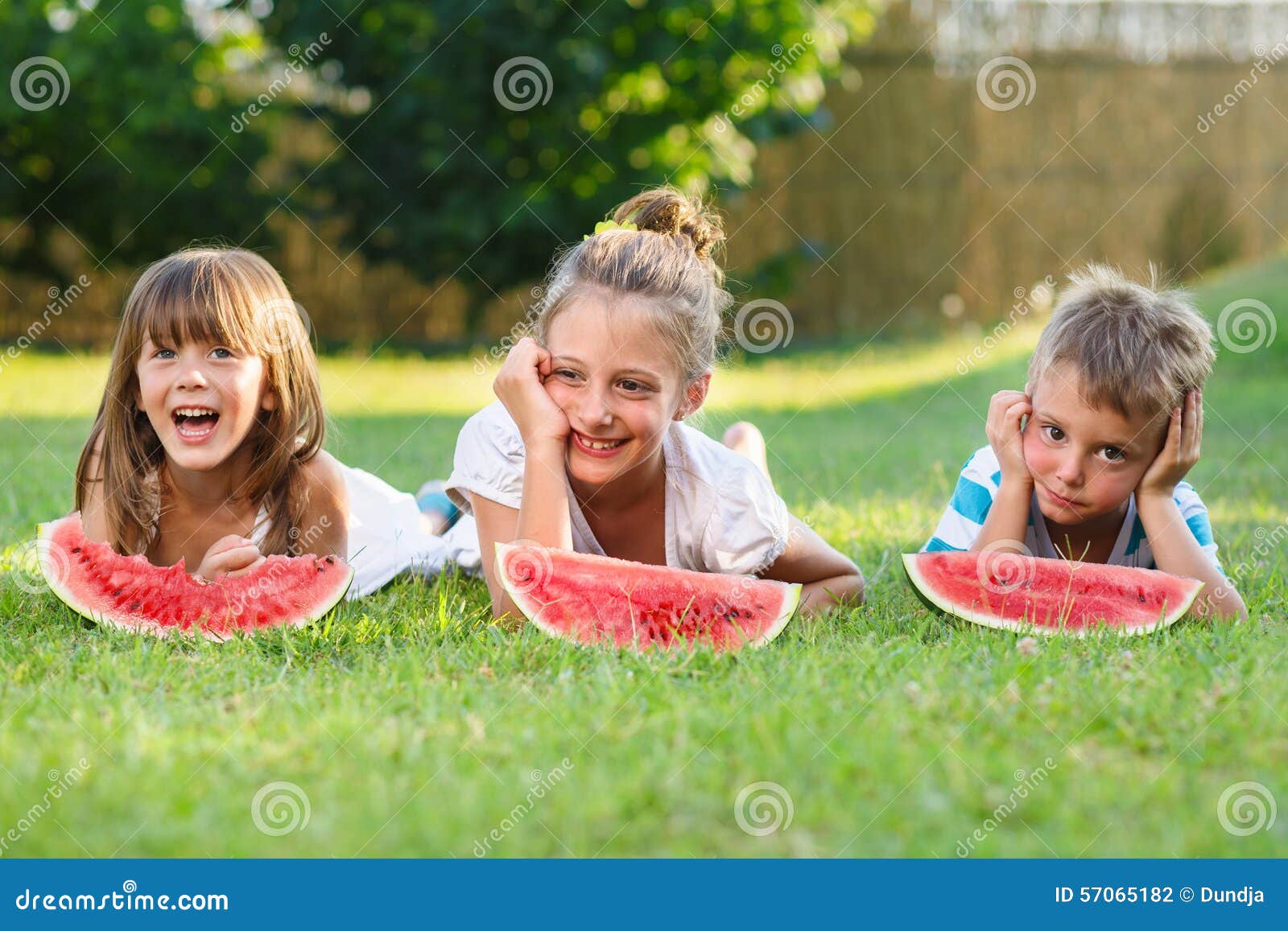 Flickor och pojke. Två flickor och en pojke som äter vattenmelon