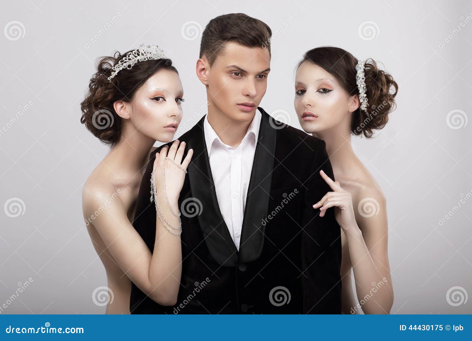 flirtation. handsome man in cuddle of two voluptuous women