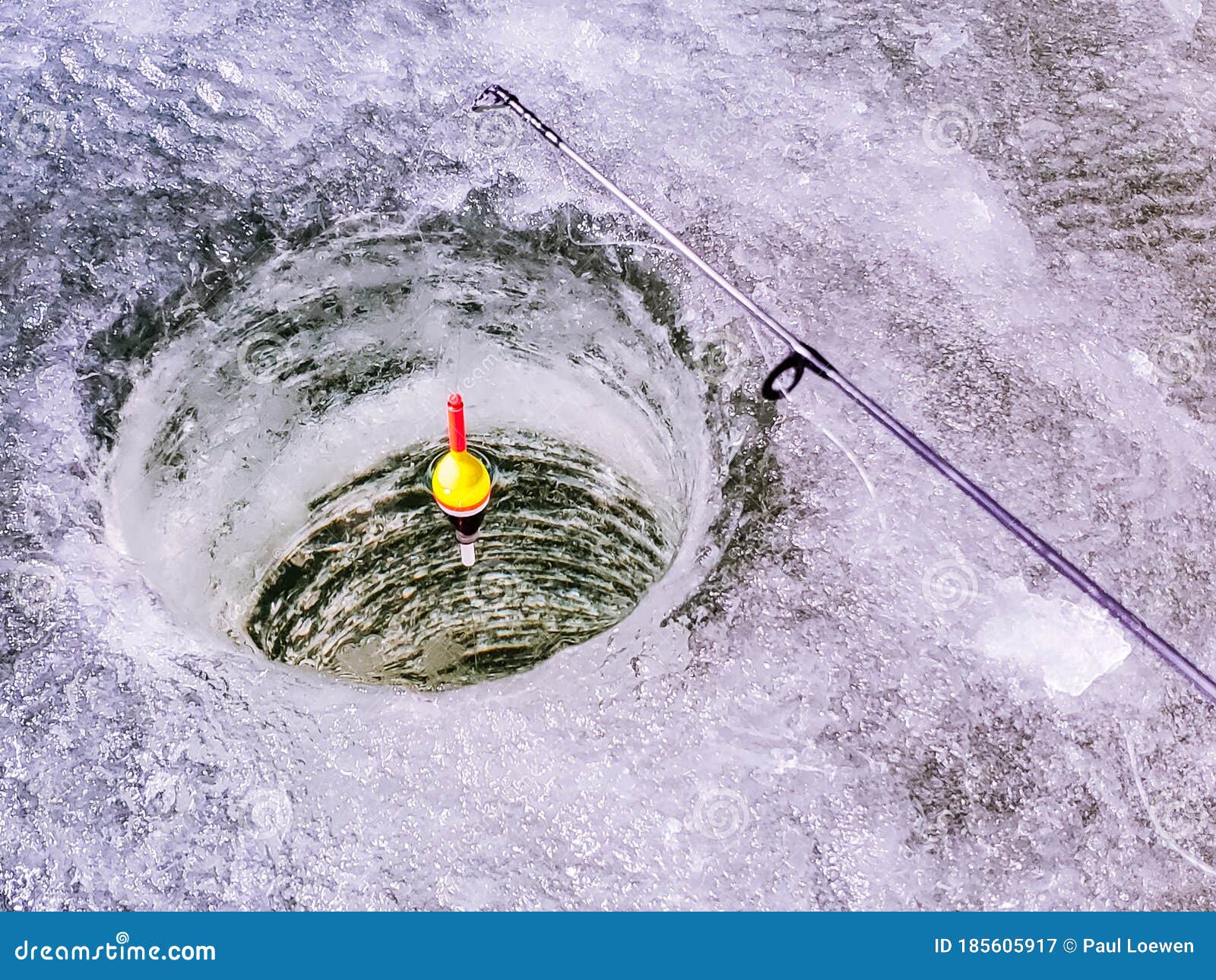 A Float Sits in a an Ice Fishing Hole. Stock Image - Image of
