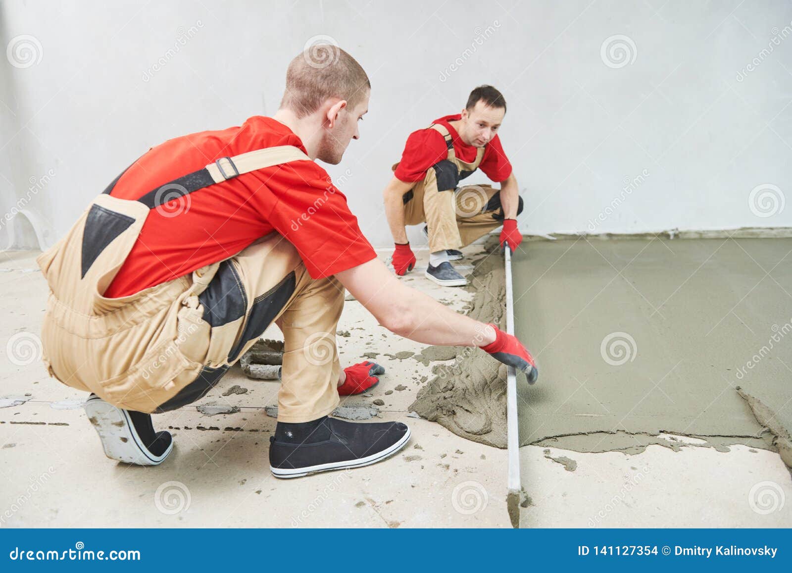 Floor Cement Work. Plasterer Smoothing Floor Surface With Screeder