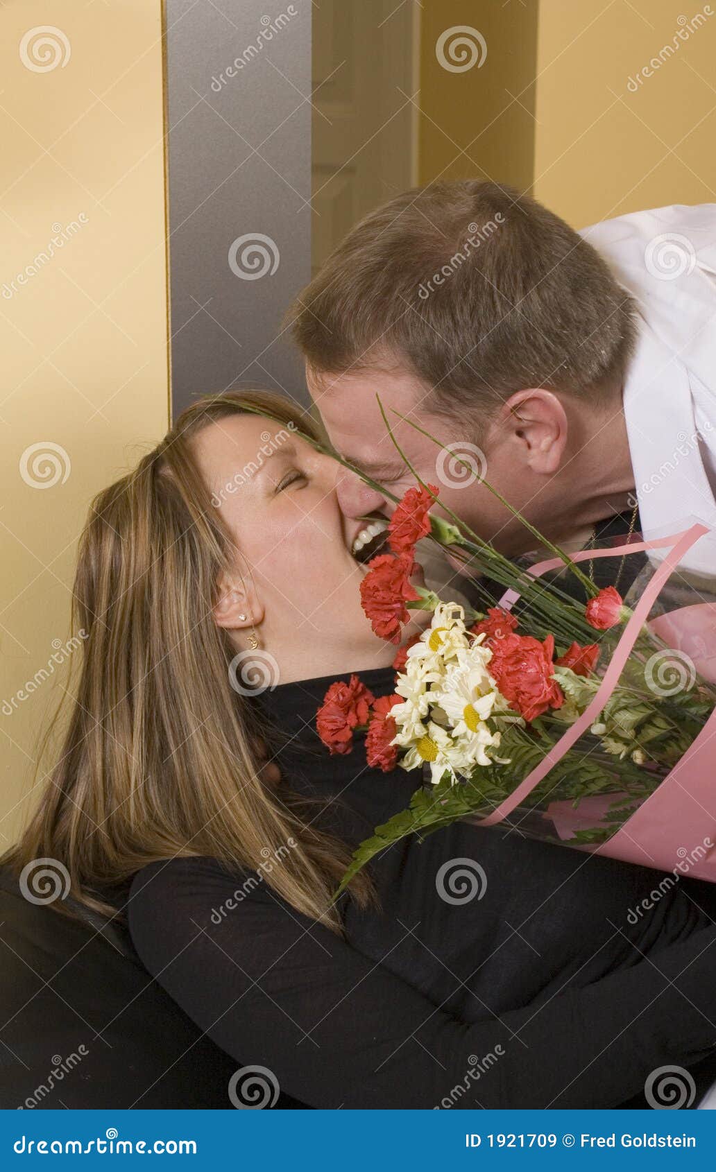 Flores de oferecimento do homem à mulher no sofá