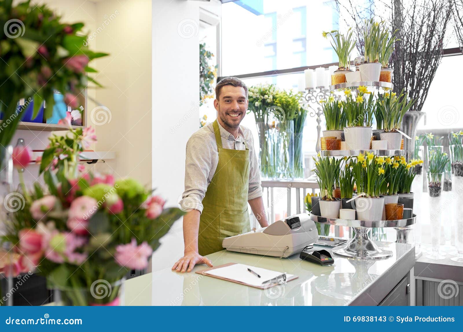 florist man with clipboard at flower shop counter