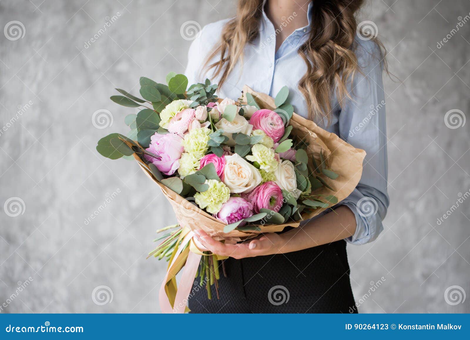 florist at work: pretty young woman making fashion modern bouquet of different flowers