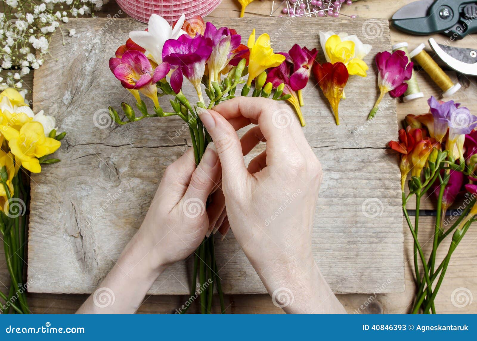 florist at work. woman making bouquet of freesia flowers